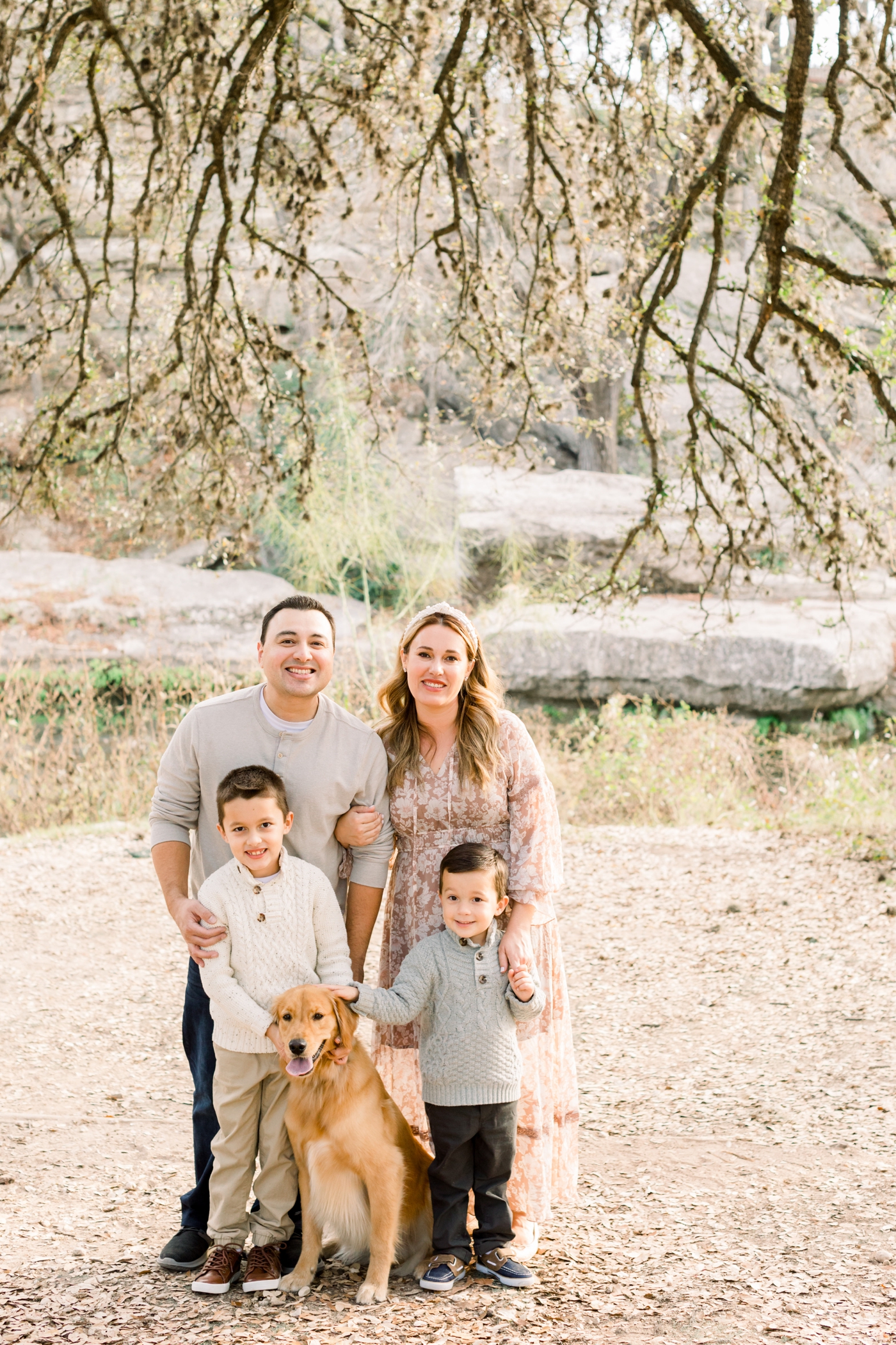 Parents with kids and dog under oak trees in Austin. Photo by Sana Ahmed Photography.
