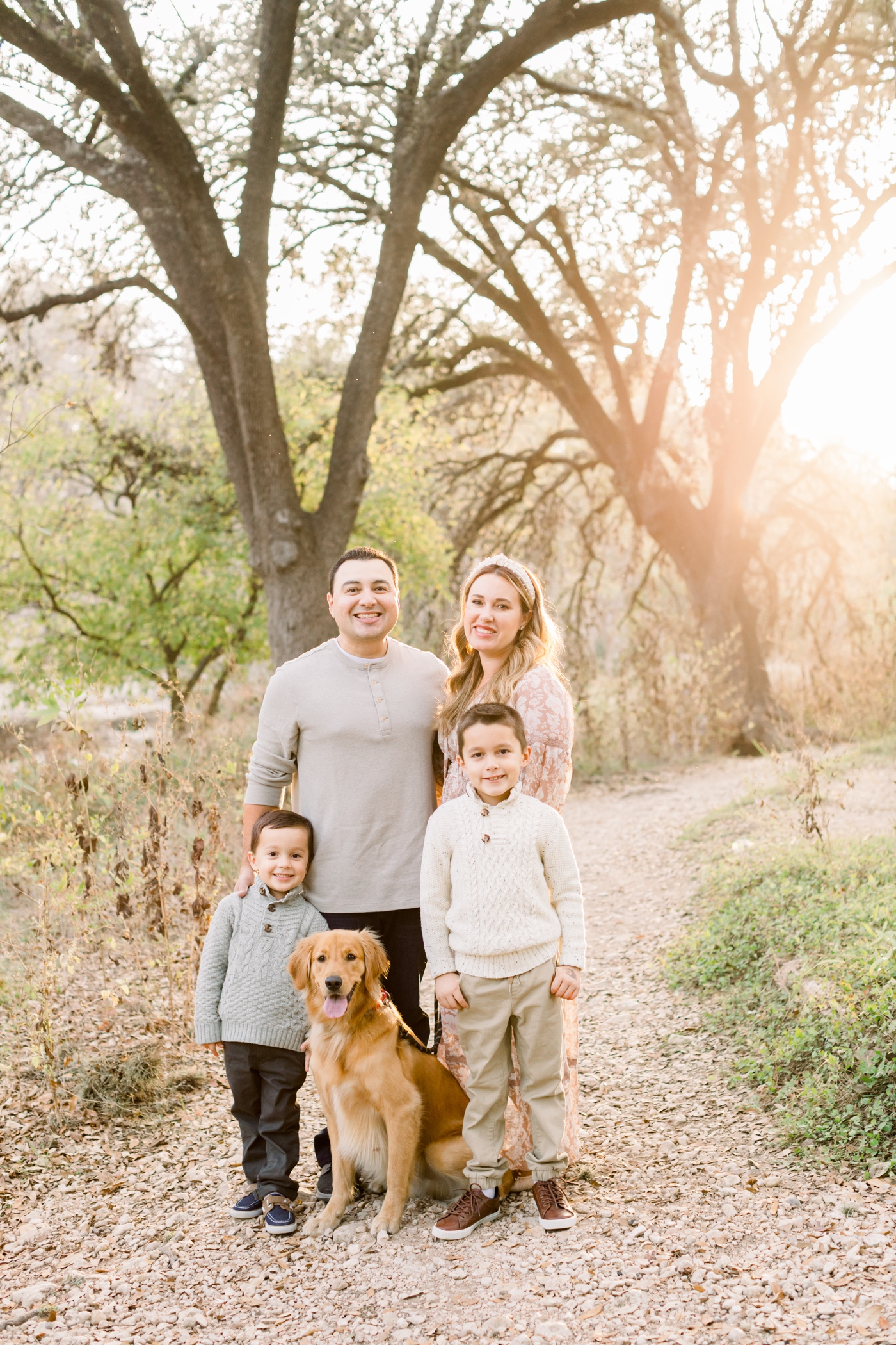 Family standing together with dog in the middle during sunset session. Photo by Sana Ahmed Photography.