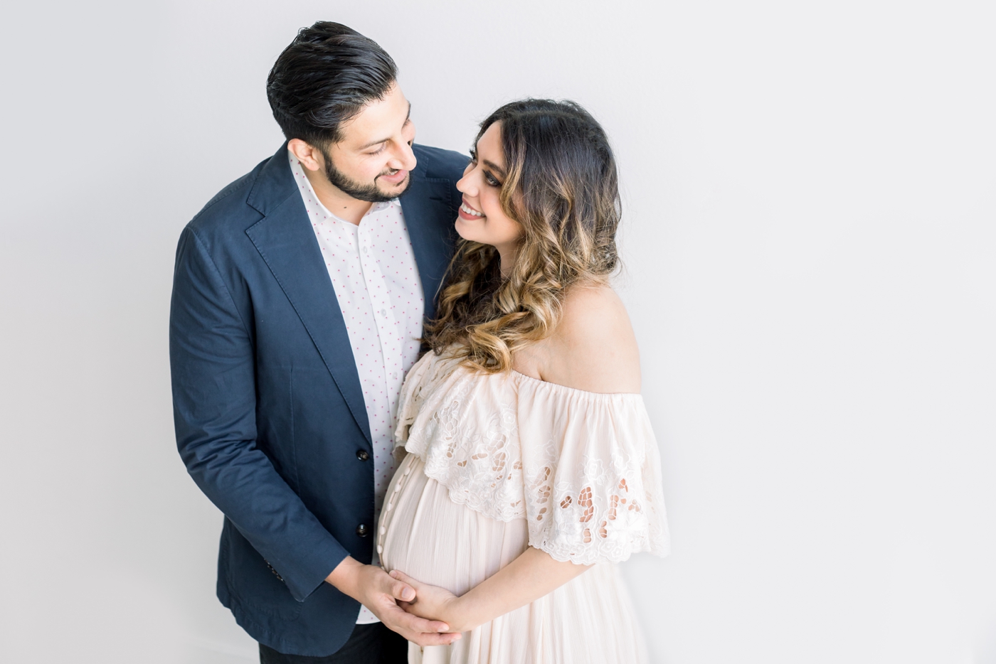 Expecting couple smiling at each other during studio session with Austin Maternity Photographer, Sana Ahmed Photography.