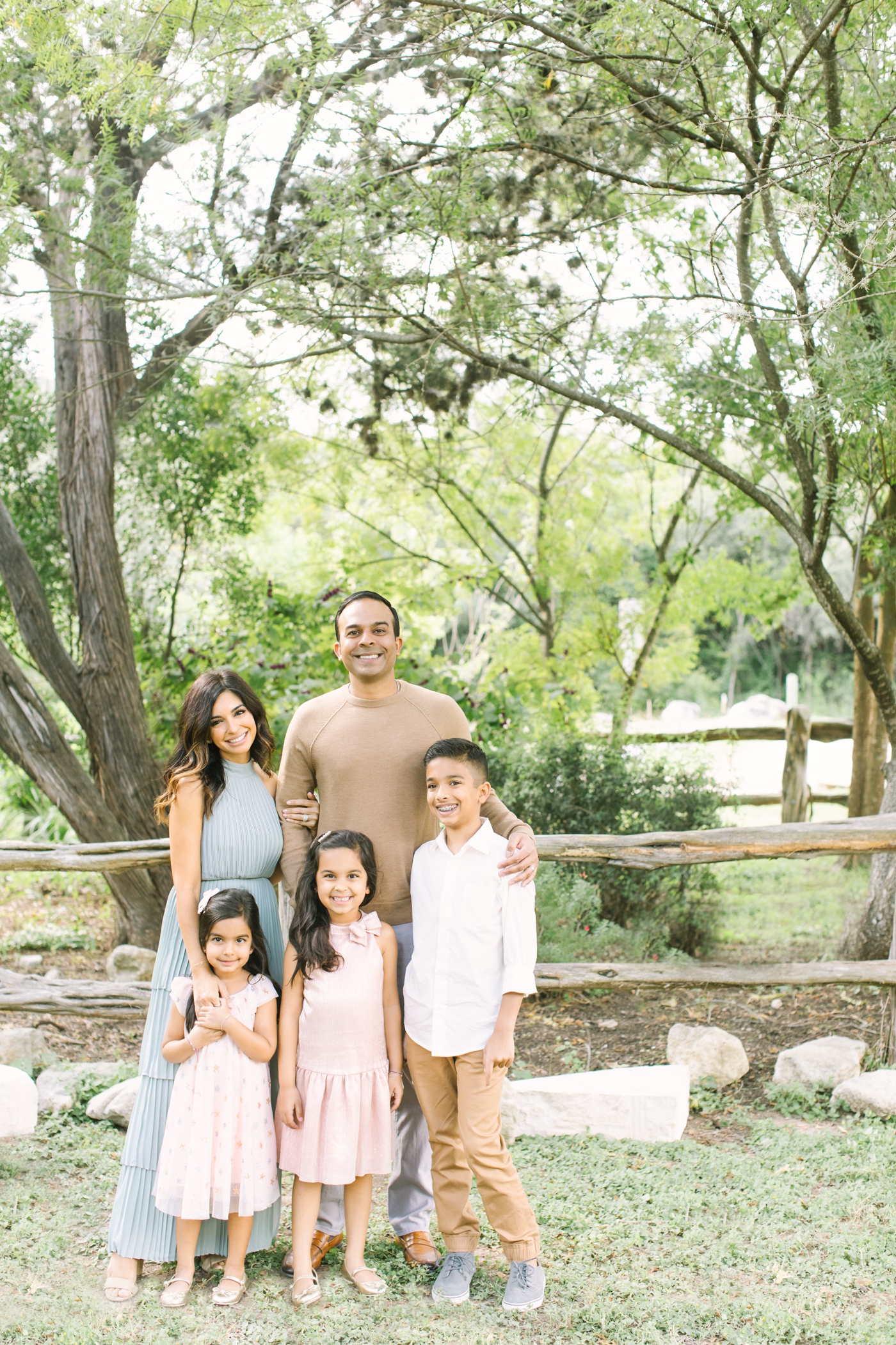 Beautiful family during field session with oaks in Austin, TX. Photo by Sana Ahmed Photography.