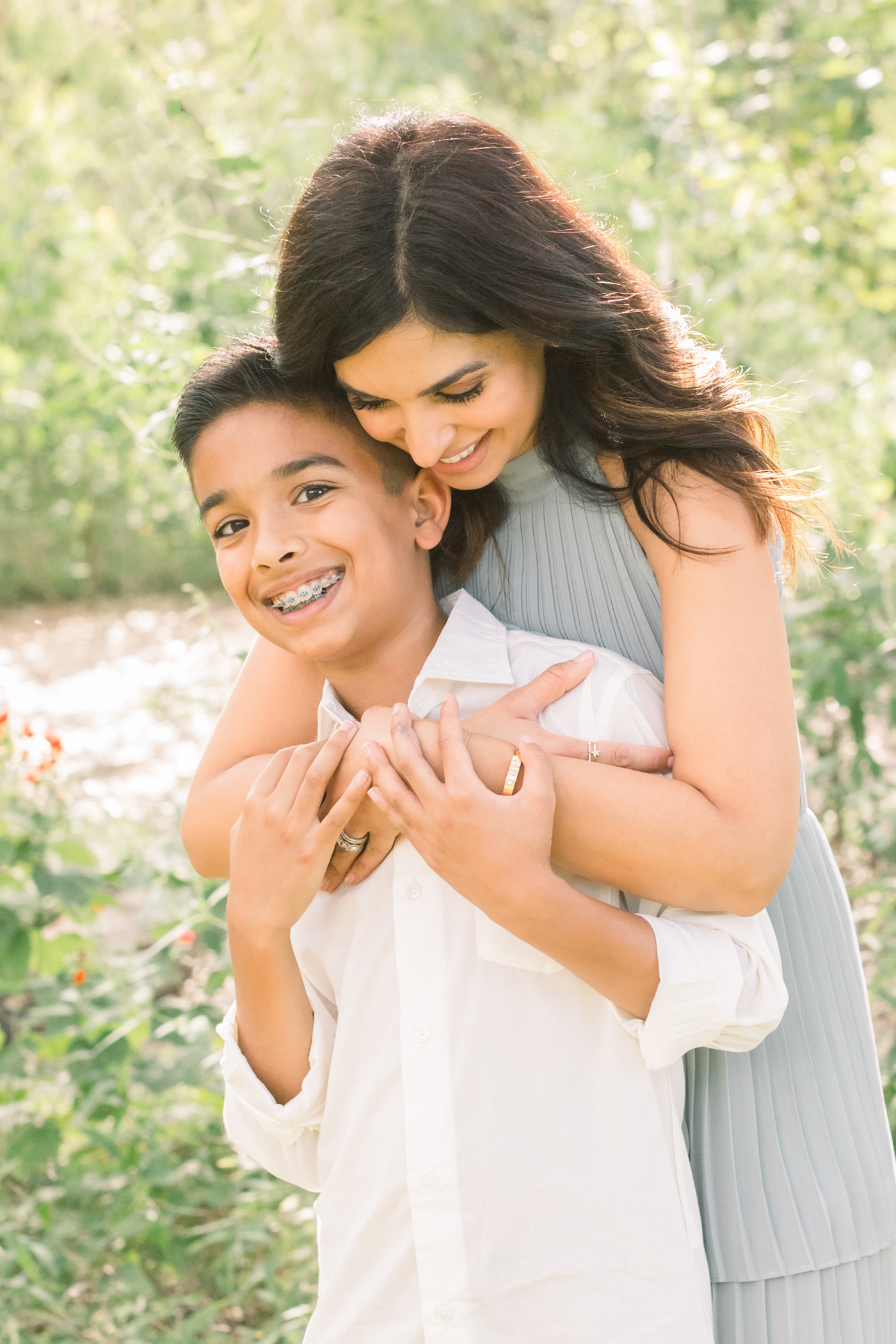 Mom hugging son during beautiful field session in Austin, TX. Photo by Sana Ahmed Photography.