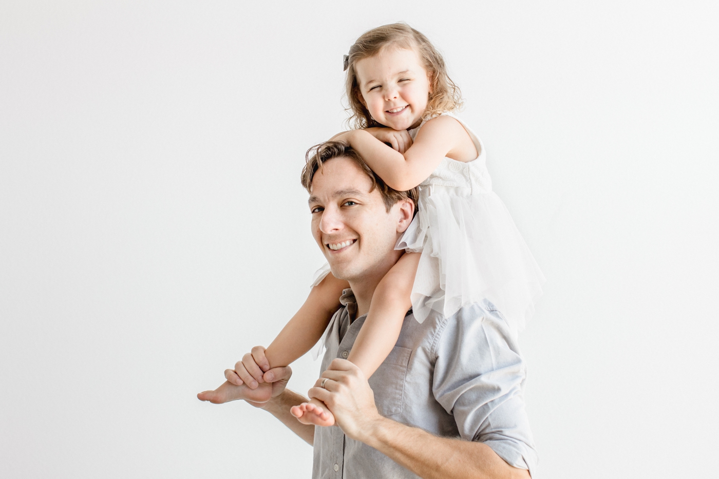 Little girl on Dad's shoulders during maternity session in Austin TX studio. Photo by Sana Ahmed Photography.
