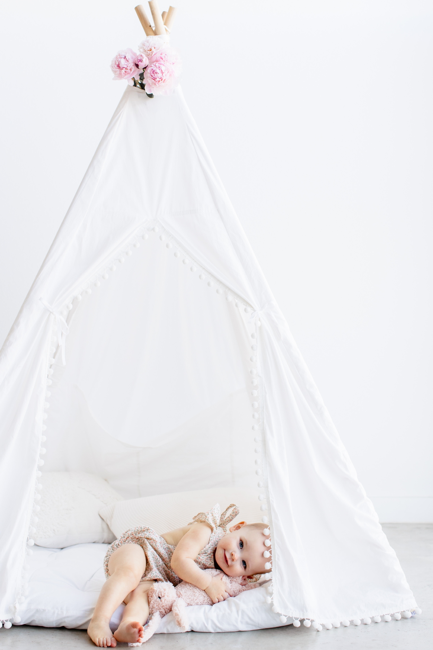 Sweet girl cuddling her stuffed animal in a teepee provided by Austin family photographer, Sana Ahmed Photography.