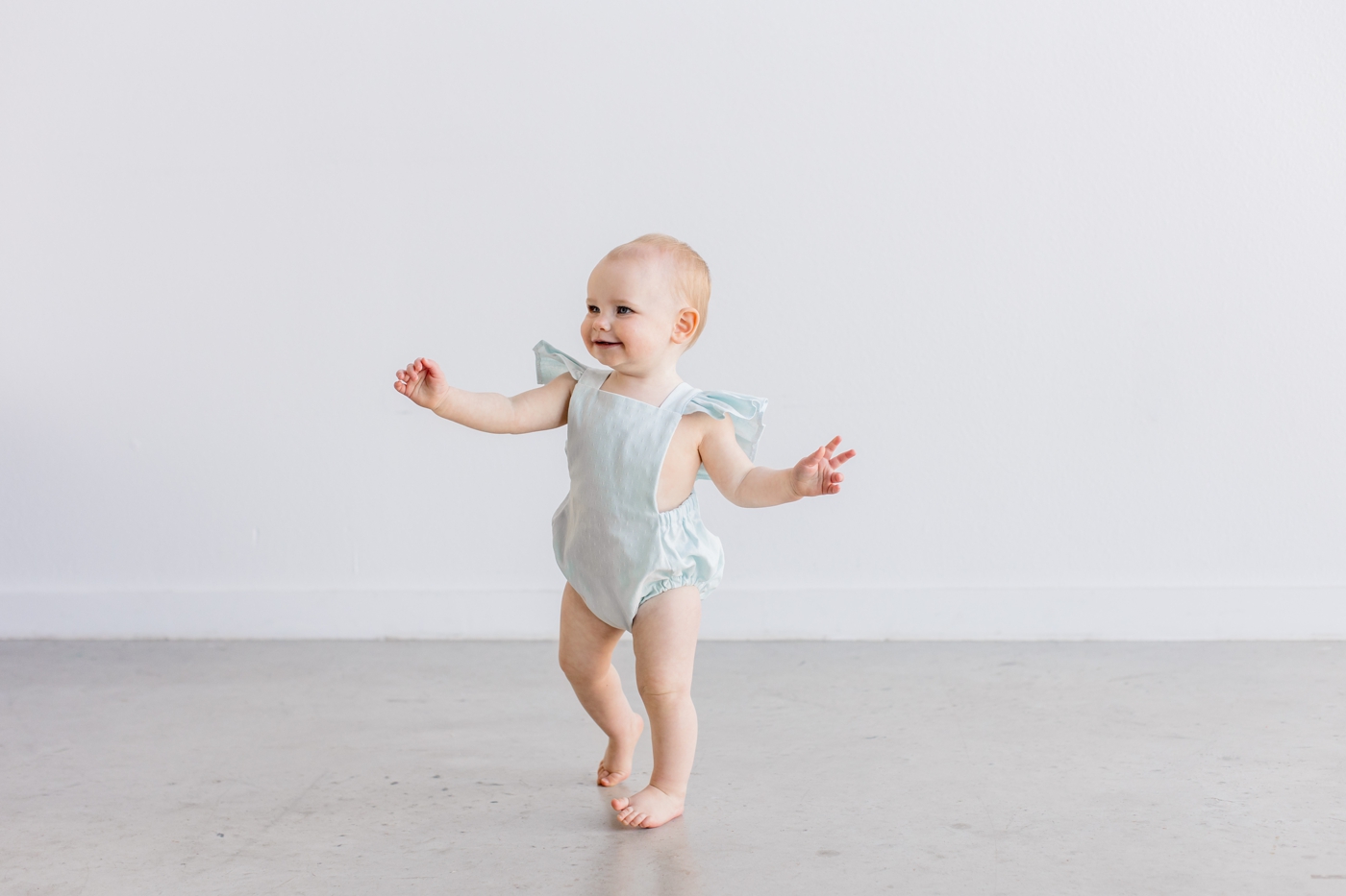 Toddler in romper during first birthday milestone session by Sana Ahmed Photography.
