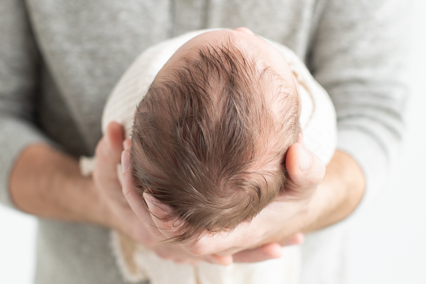 Closeup of newborn baby's hair while Dad holds him. Photo by Sana Ahmed Photography.
