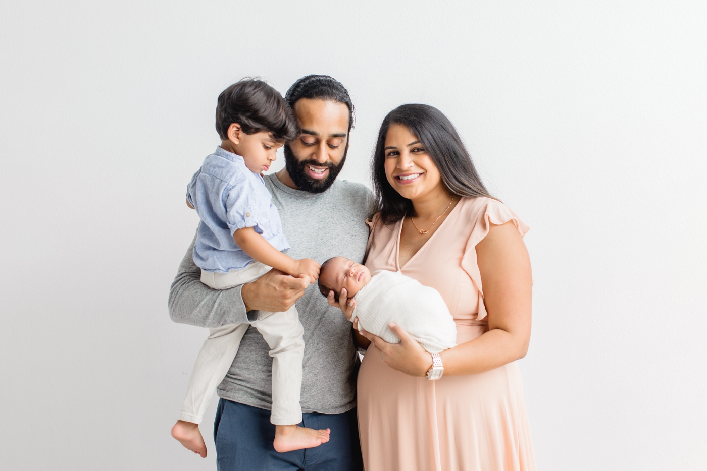 Family of four portrait during in studio newborn session in Austin TX. Photo by Sana Ahmed Photography.