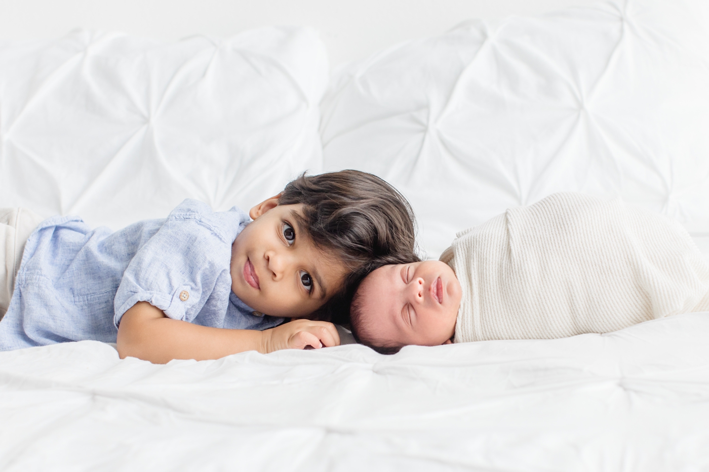Sweet moment where big brother laid next to baby during newborn session in Austin TX. Photo by Sana Ahmed Photography.