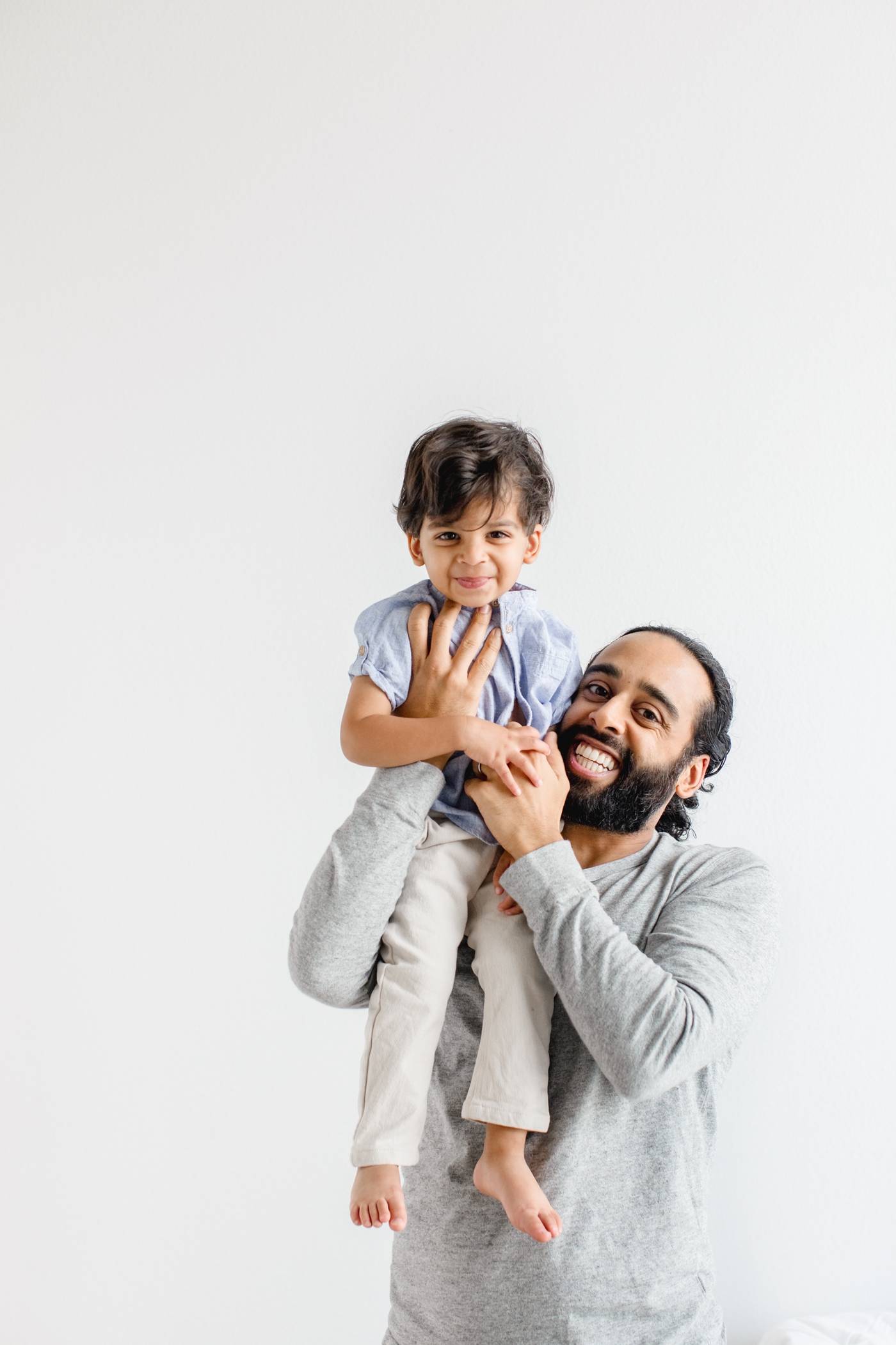 Toddler and Dad laughing and playing in studio session in Austin TX.Photo by Sana Ahmed Photography.