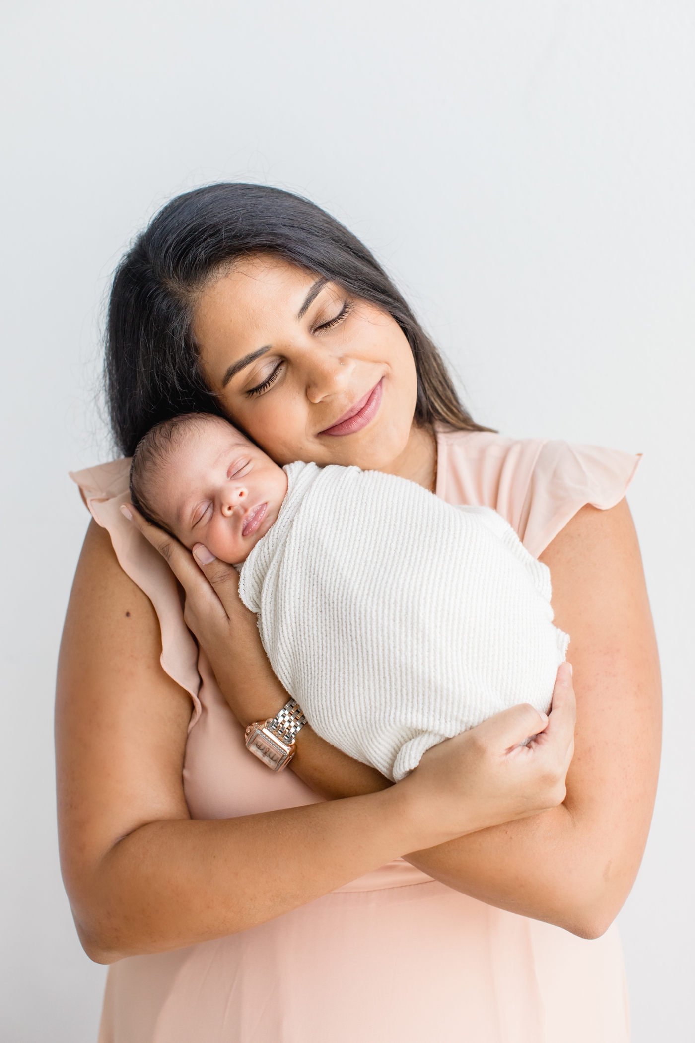 Mom cuddling baby during newborn session in studio. Photo by Sana Ahmed Photography.