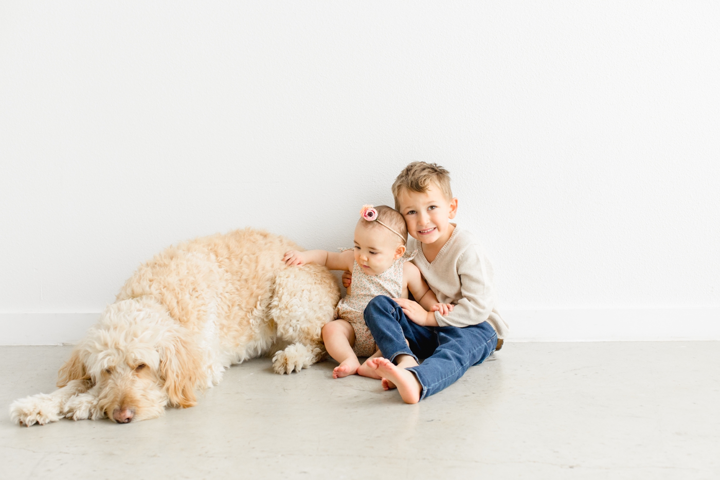 Two kids with family dog during in-studio session. Photo by Austin family photographer, Sana Ahmed Photography.