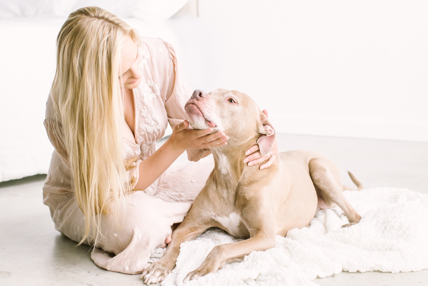 Mom petting dog during studio family session. Photo by Sana Ahmed Photography.