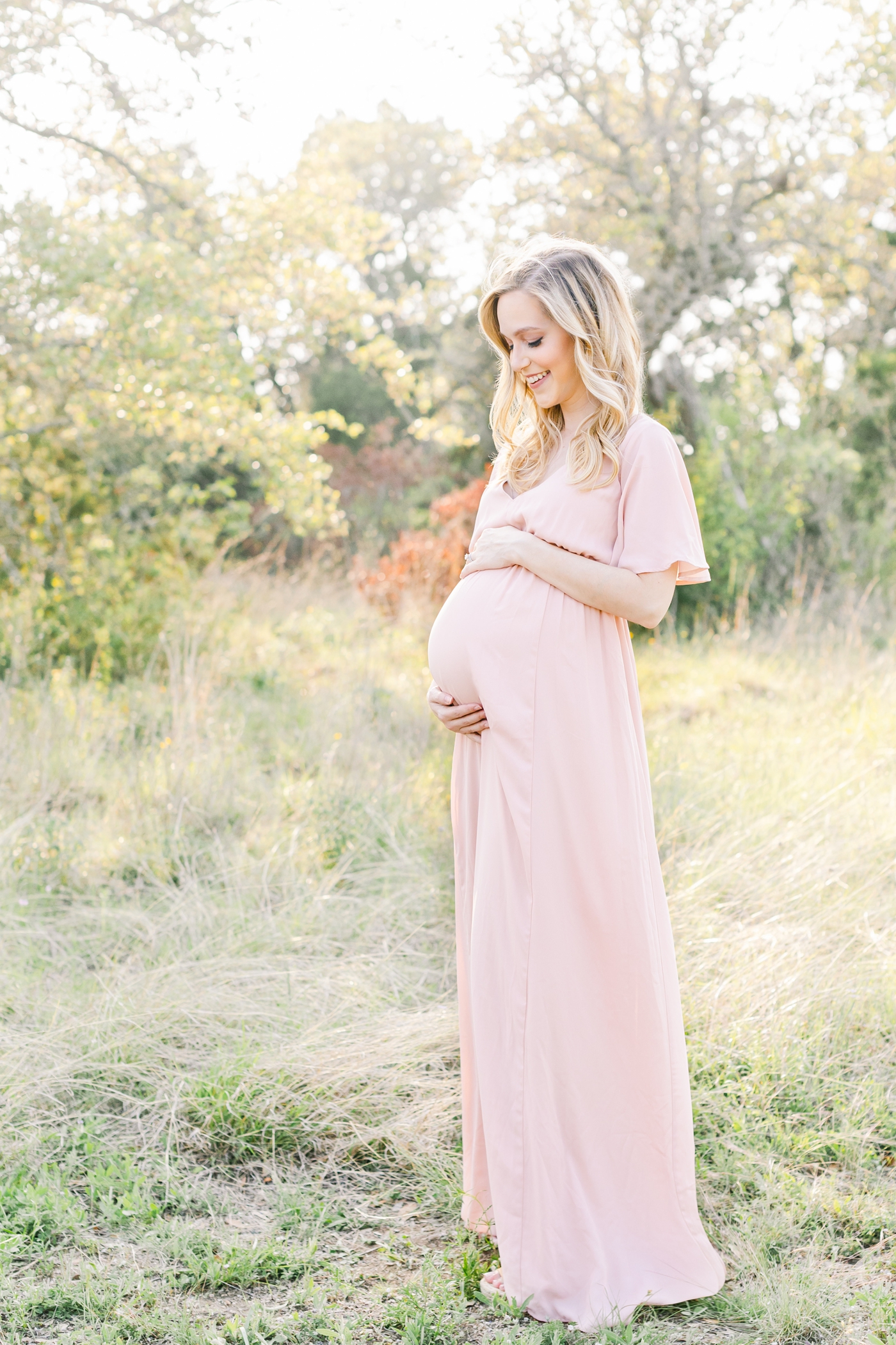 Mom wearing pink maxi dress during maternity session in Austin TX. Photo by Sana Ahmed Photography.