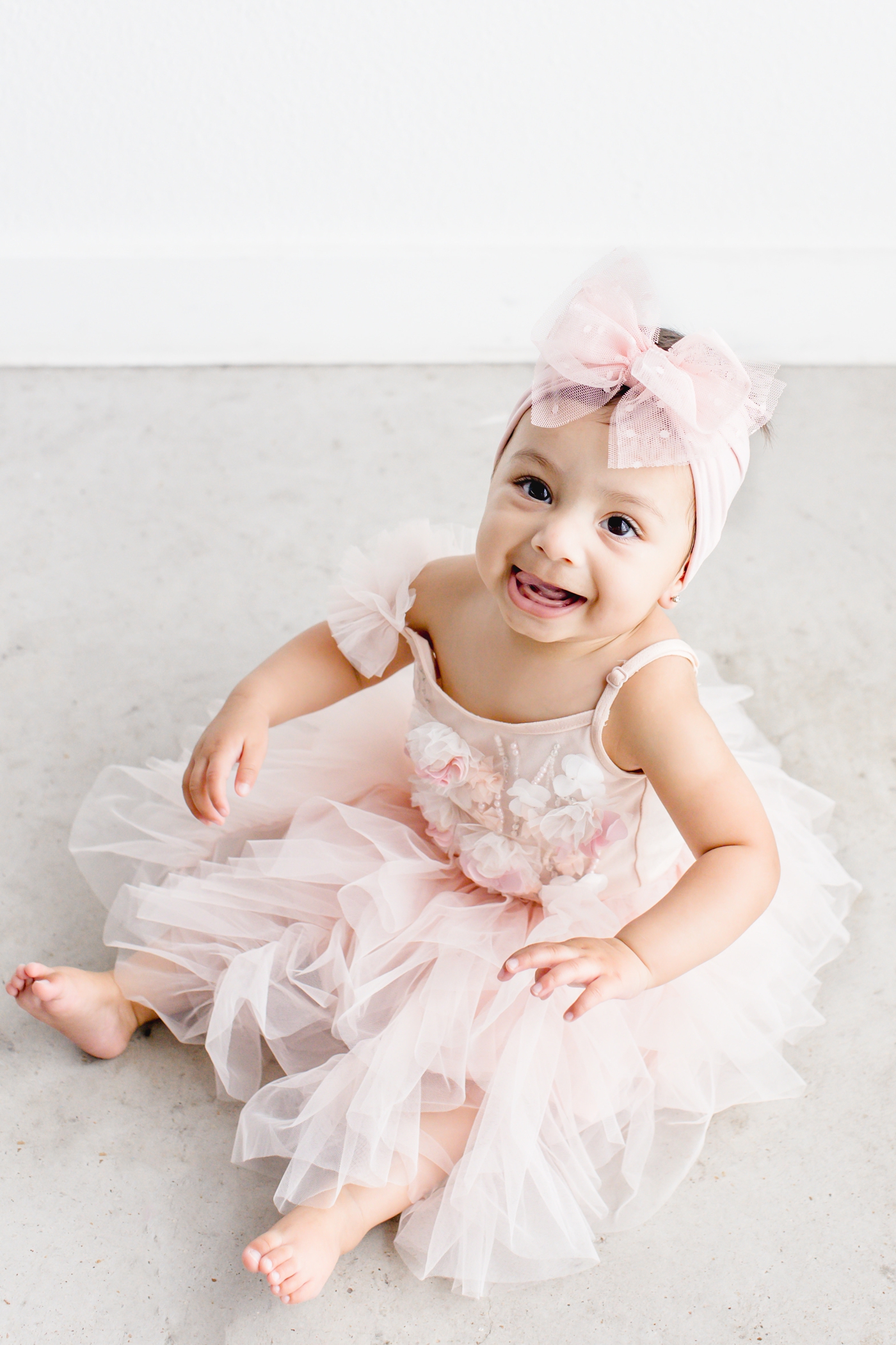 Baby girl sitting in light pink tutu during milestone photo session. Photo by Sana Ahmed Photography.