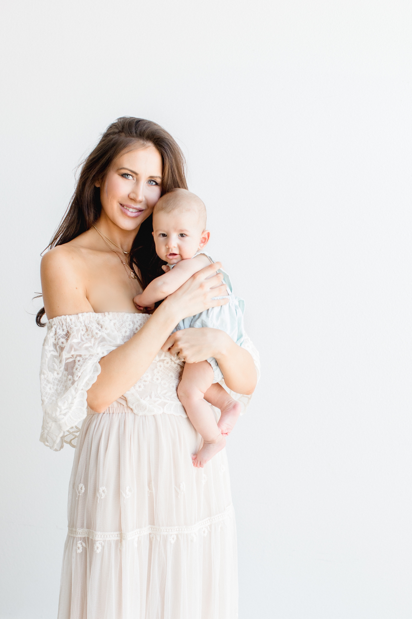 Beautiful Mom wearing lace maxi dress holding baby. Photo by Austin family photographer, Sana Ahmed Photography.