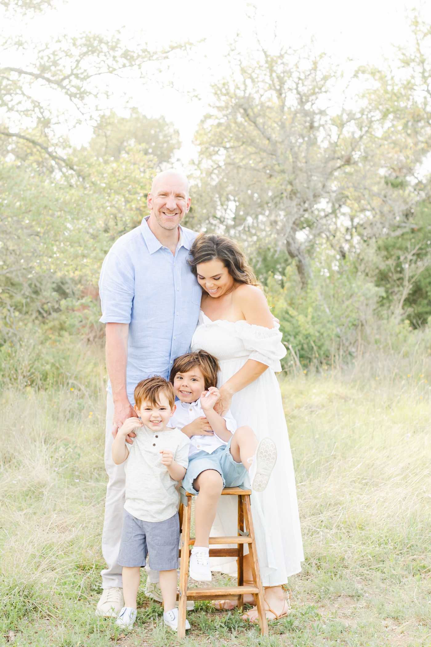 Family photoshoot in Cedar Park with Mom tickling big brother. Photo by Sana Ahmed Photography.
