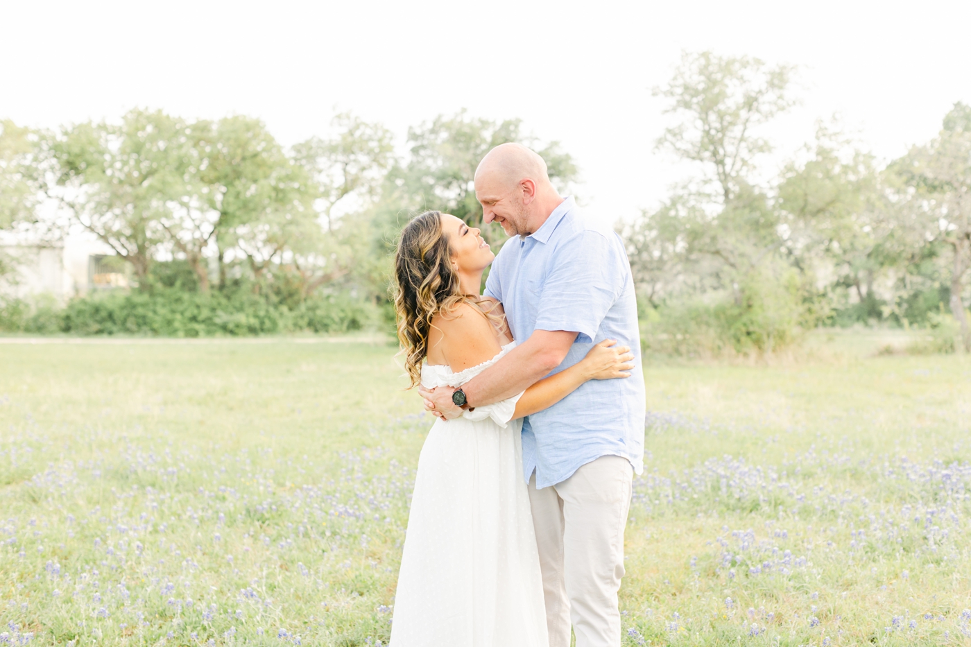 Sweet image of Mom and Dad looking at each other and hugging during family photoshoot in Cedar Park. Photo by Sana Ahmed Photography.