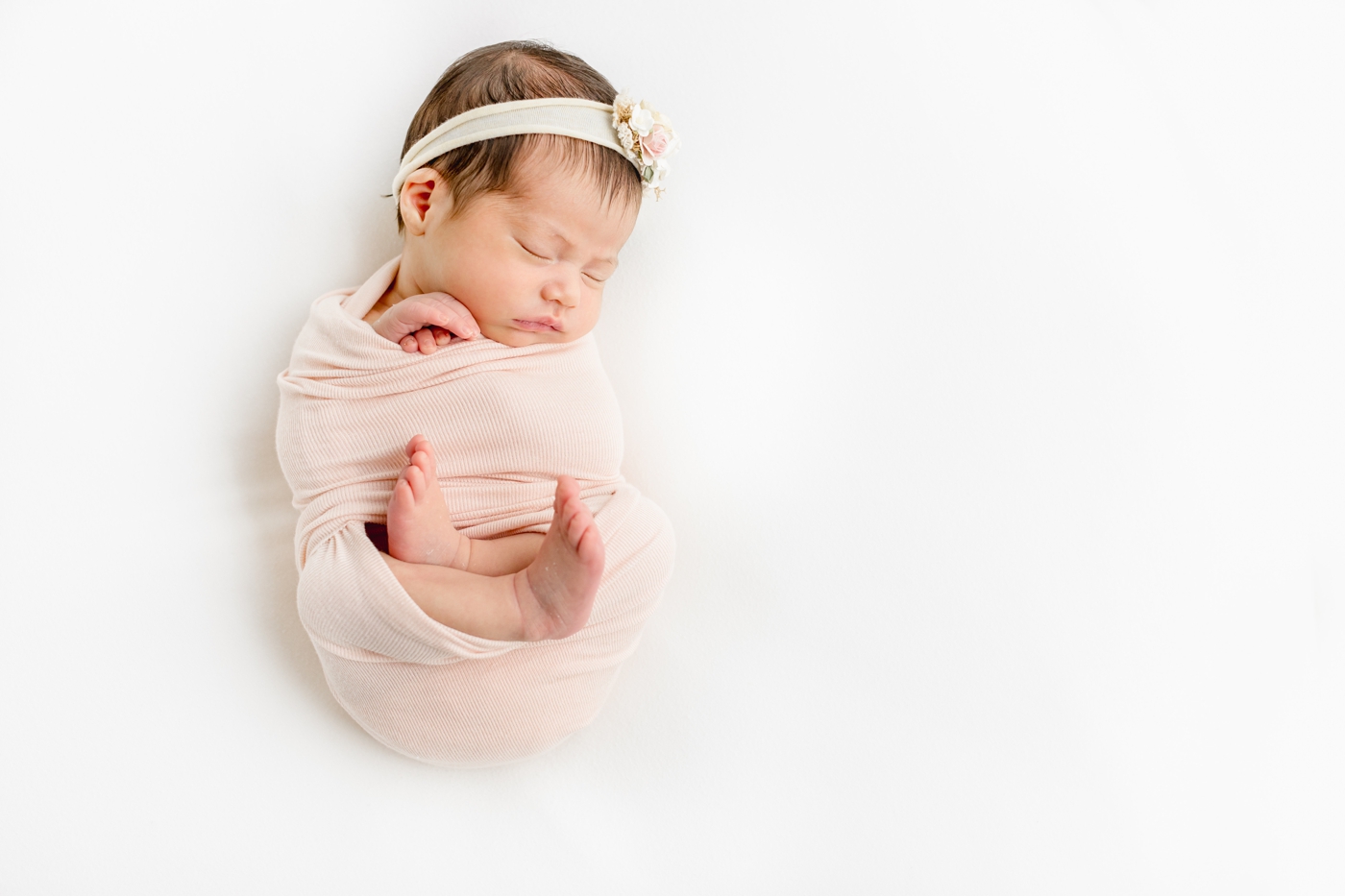 Baby in pink swaddle with toes unwrapped by Austin photographer, Sana Ahmed Photography.