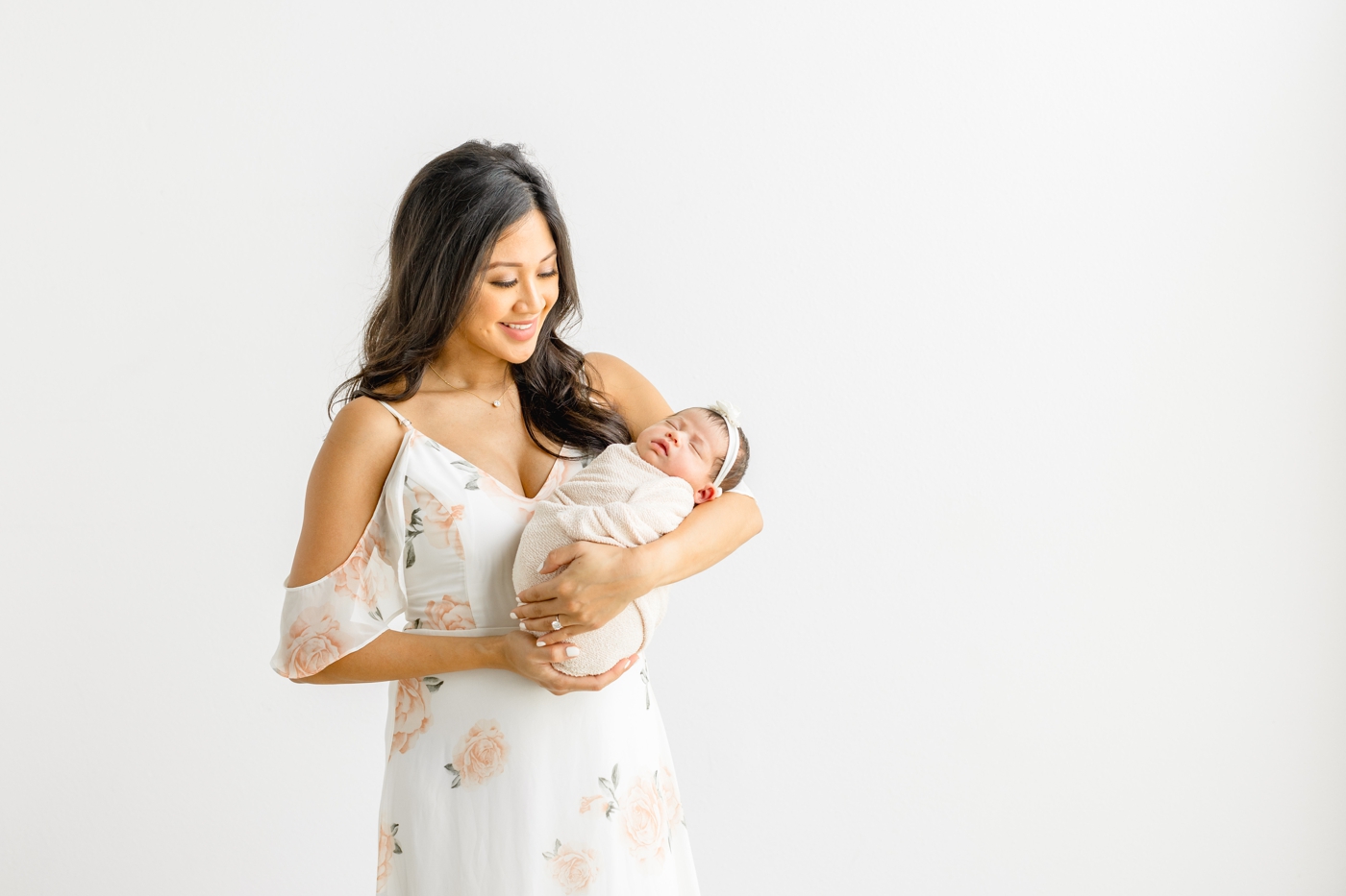 Mom wearing floral white maxi dress during studio newborn session. Photo by Sana Ahmed Photography.