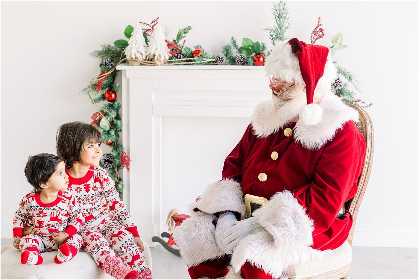 Santa wearing mask with children smiling at him. Photo by Sana Ahmed Photography.