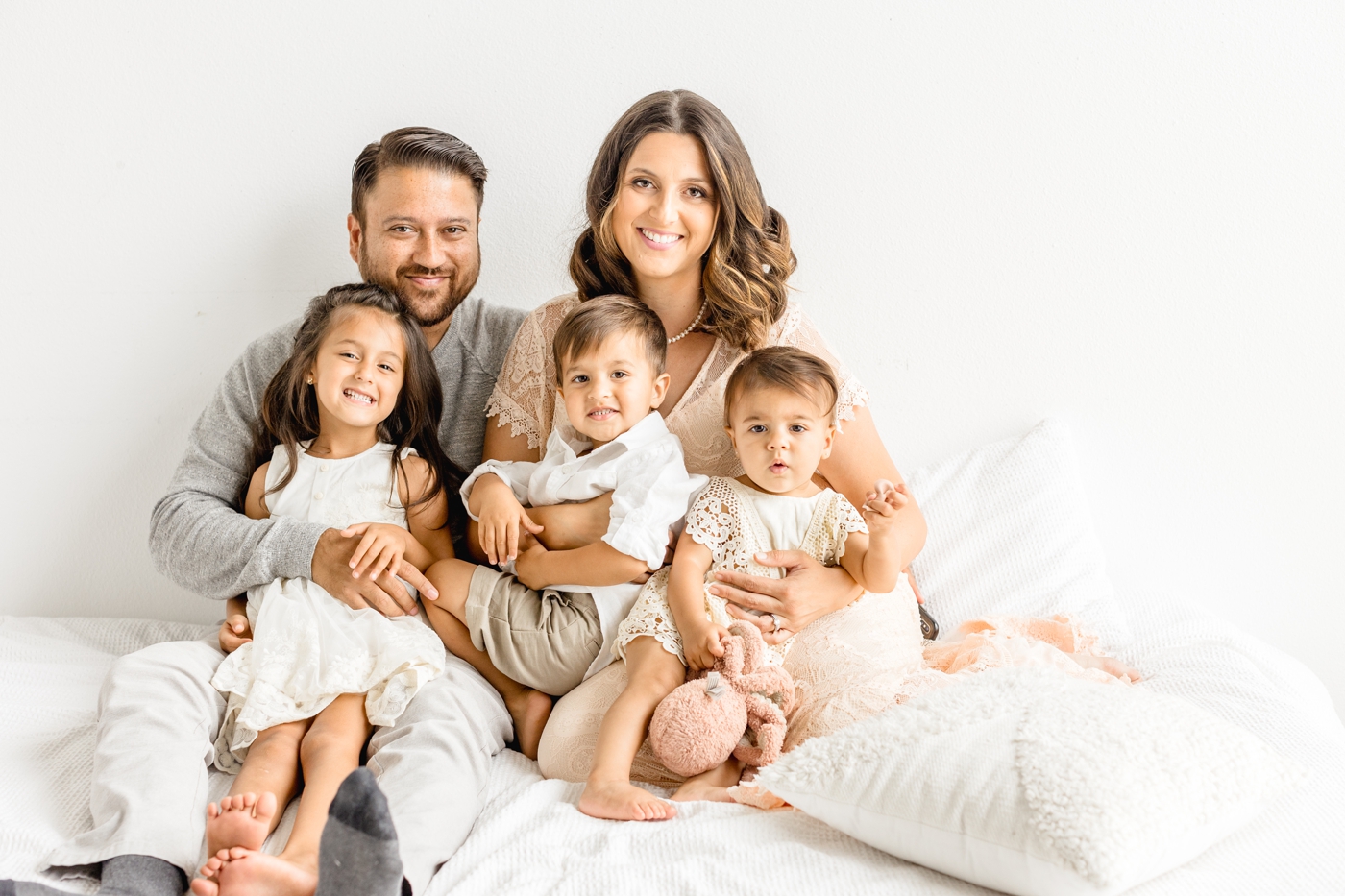 Portrait of family of five smiling at camera with full service family photographer, Sana Ahmed Photography.