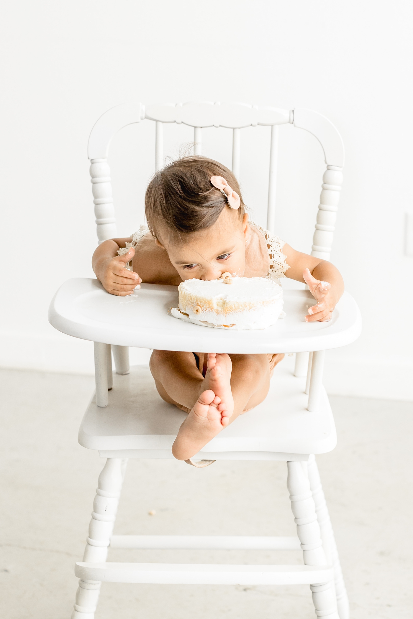 Birthday girl digging into smash cake. Photo by Sana Ahmed Photography.