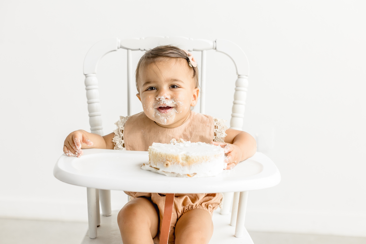 Smiling baby girl after cake smash. Photo by Sana Ahmed Photography.