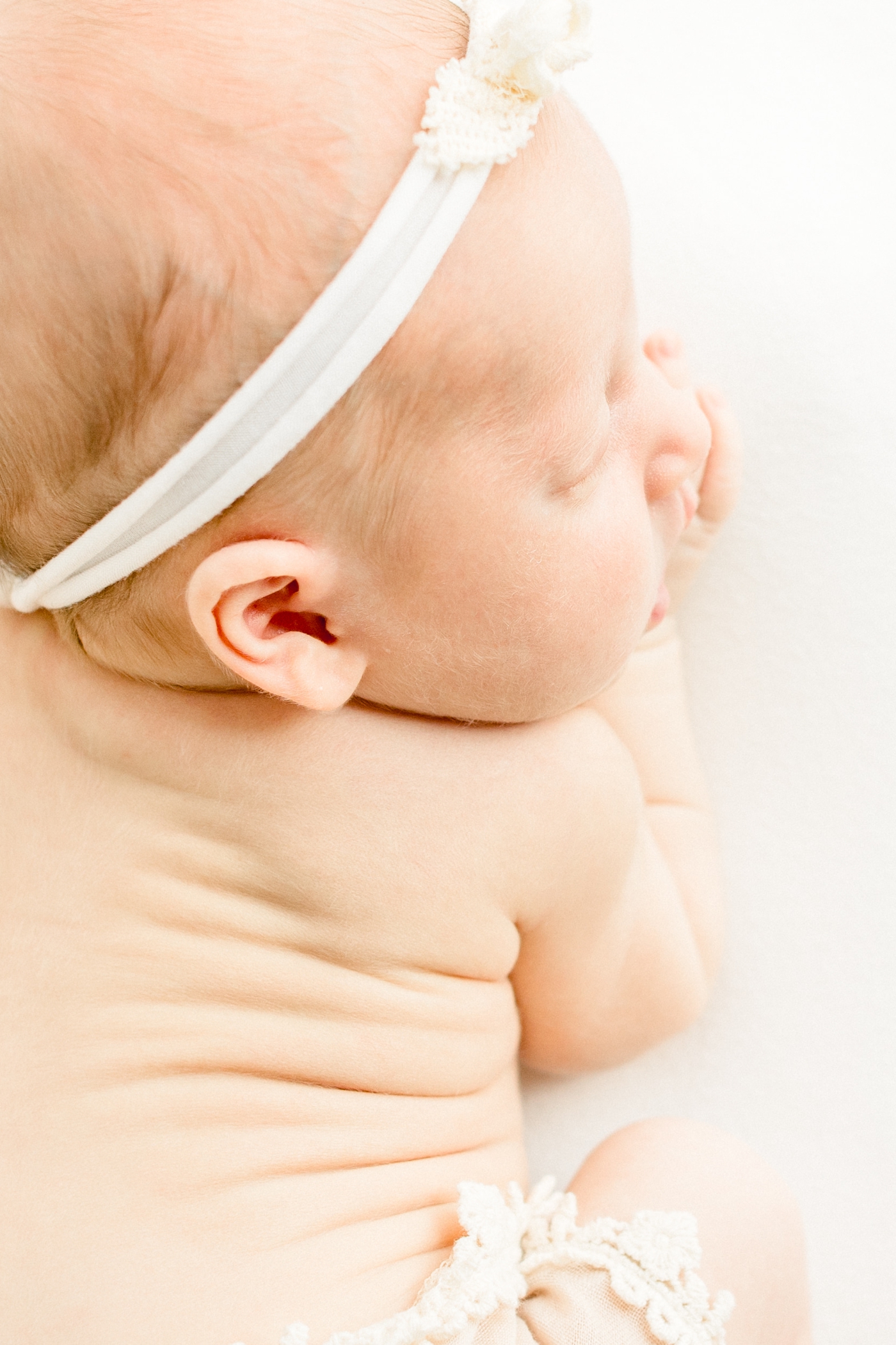 Detail image of baby's rolls and little ears during studio newborn session. Photo by Sana Ahmed Photography.