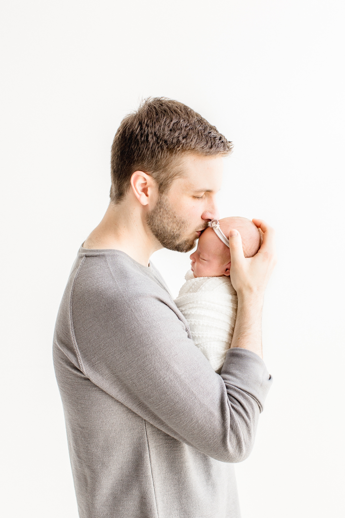 Dad kissing baby during studio newborn session in Austin, TX. Photo by Sana Ahmed Photography.