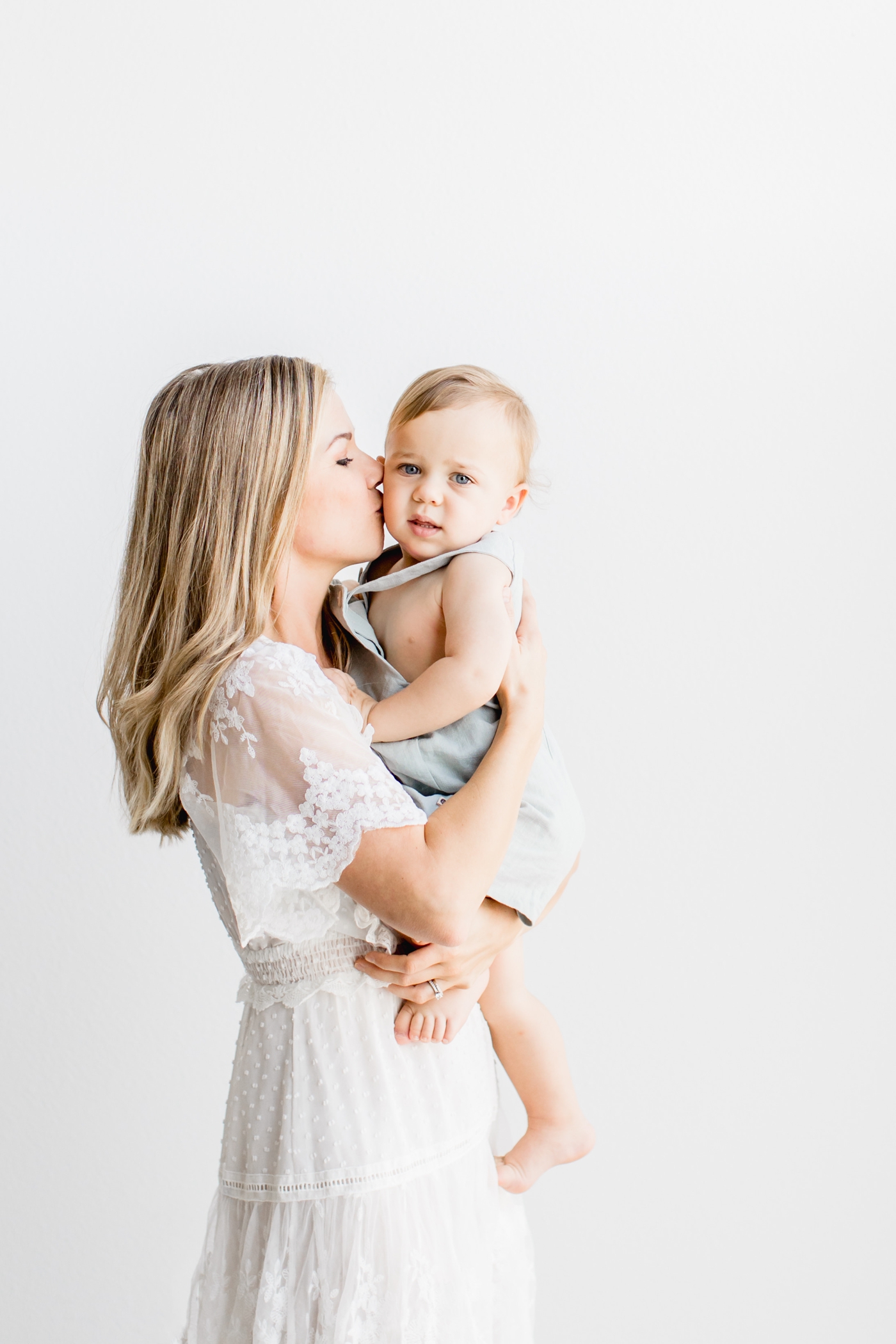 Mom kissing toddler in studio motherhood session. Photo by Sana Ahmed Photography.
