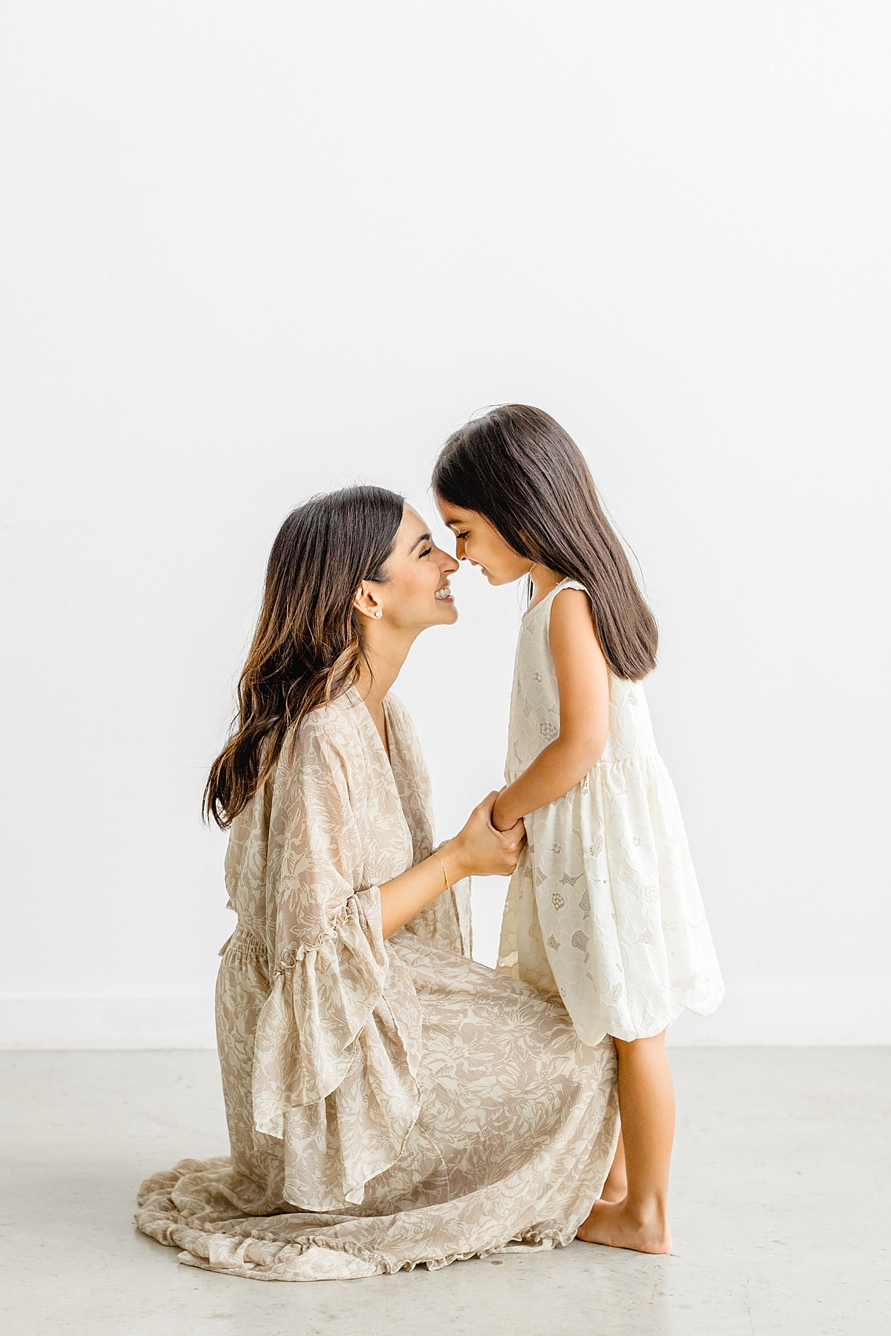 Sweet moment between Mom and daughter during family session in Austin studio by Sana Ahmed Photography.