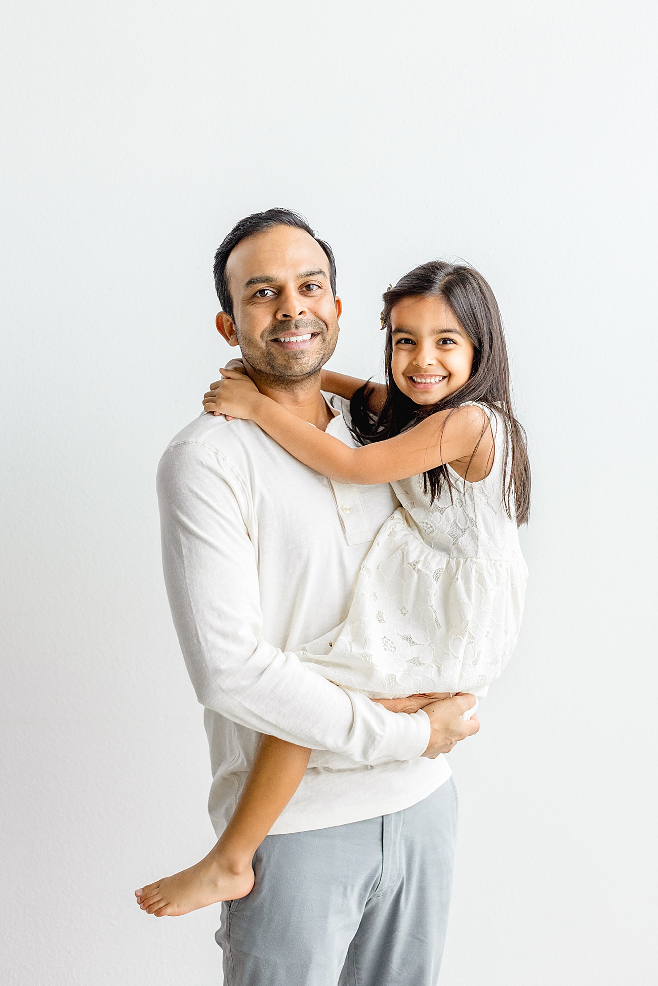 Dad smiling with daughter in Austin photography studio with Sana Ahmed Photography.