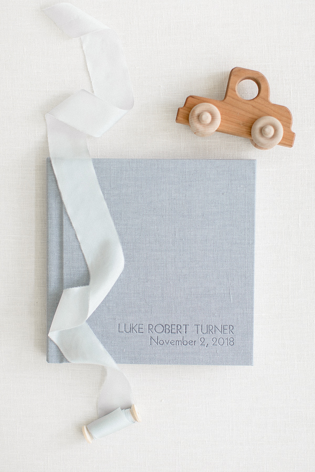 Flatlay with blue linen album designed by Austin baby photographer, Sana Ahmed Photography.