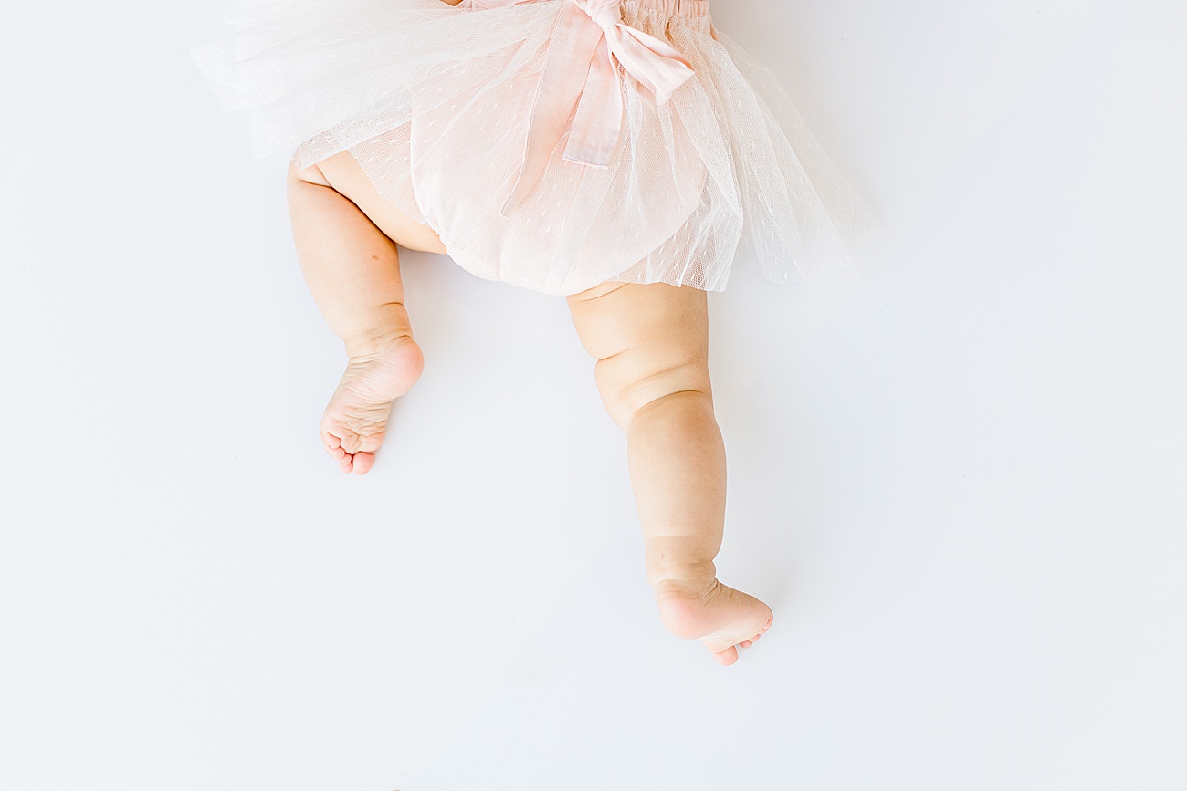 Adorable detail photo of baby's legs and she crawls in studio milestone in Austin, TX.