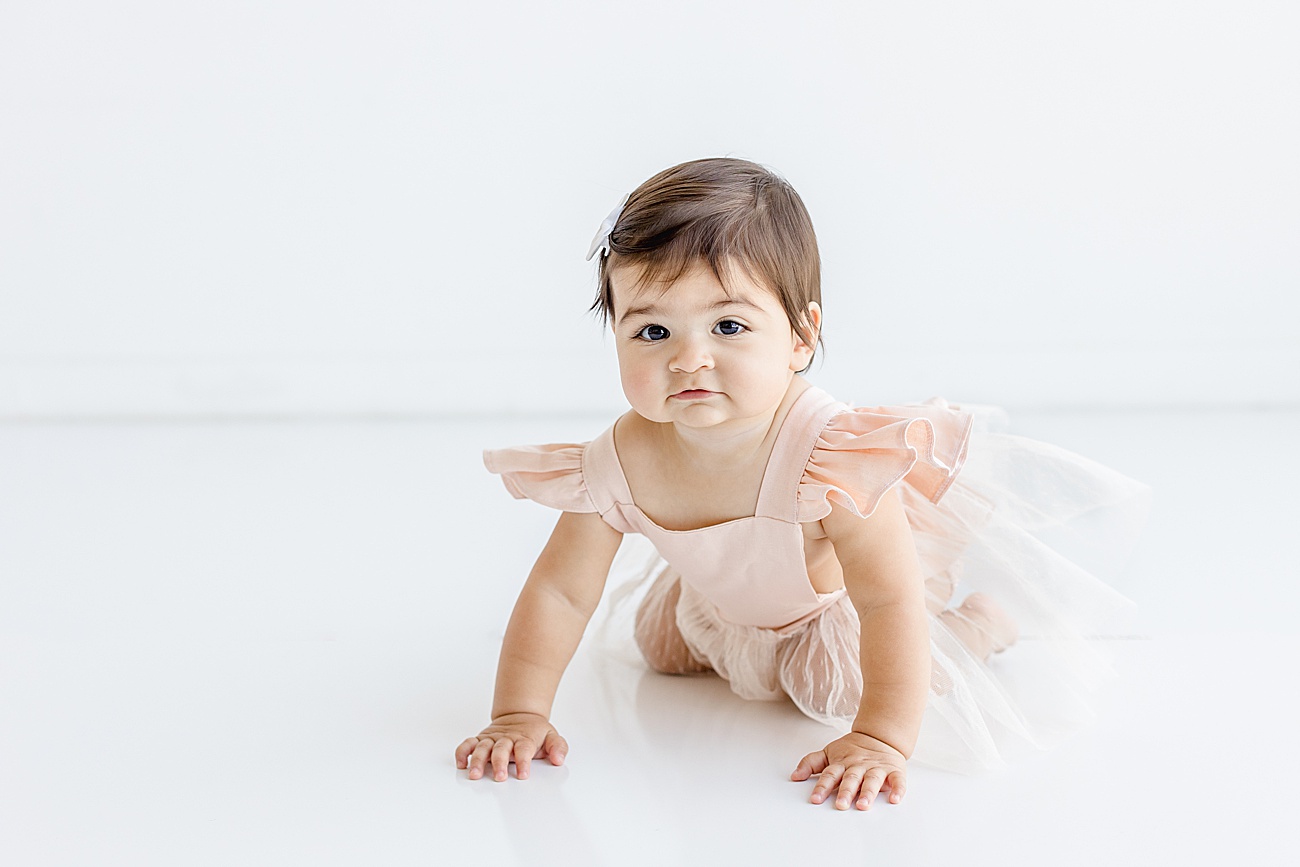 Baby crawling during one year milestone portraits in Austin, Texas studio. Photo by Sana Ahmed Photography