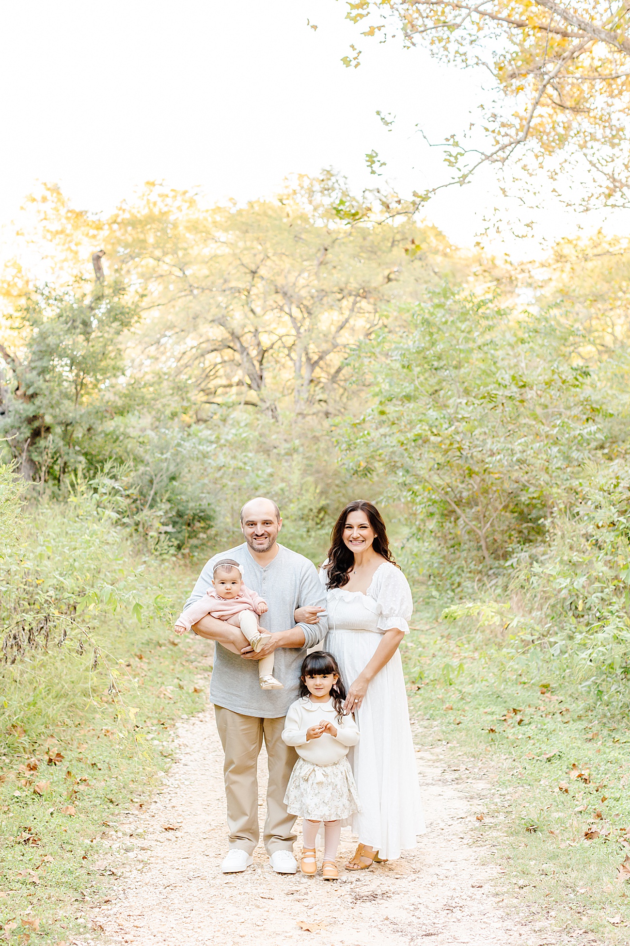 Family of four portrait in beautiful Austin, TX field. Photo by Sana Ahmed Photography.