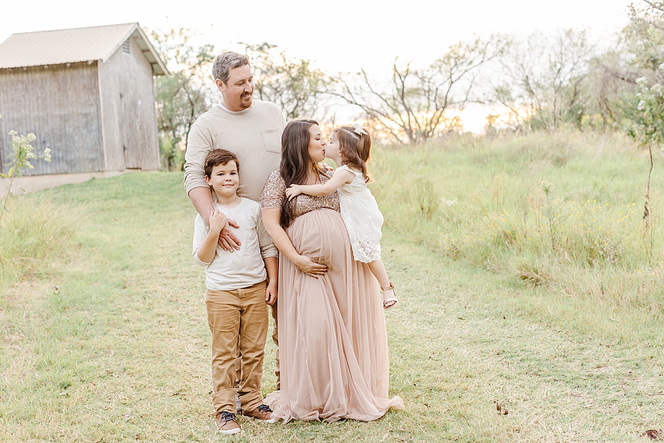 Sweet maternity session with older siblings in Austin, TX field. Photo by Sana Ahmed Photography