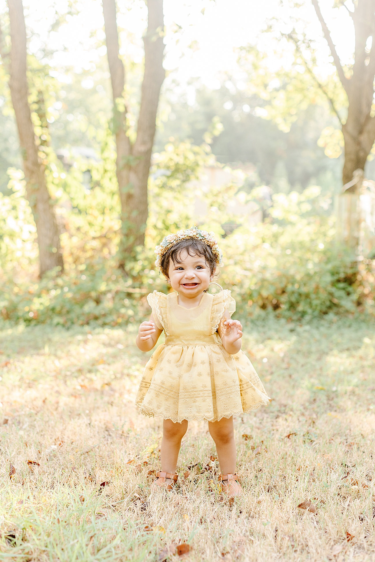 Beautiful baby girl in sunlit field. Photo by Sana Ahmed Photography