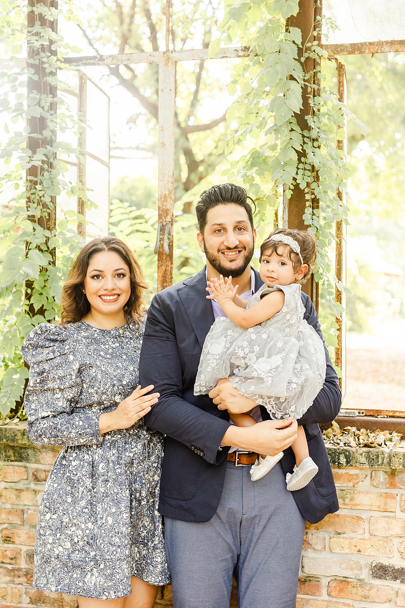 Family of three smiling at camera during family session with Austin family photographer, Sana Ahmed Photography