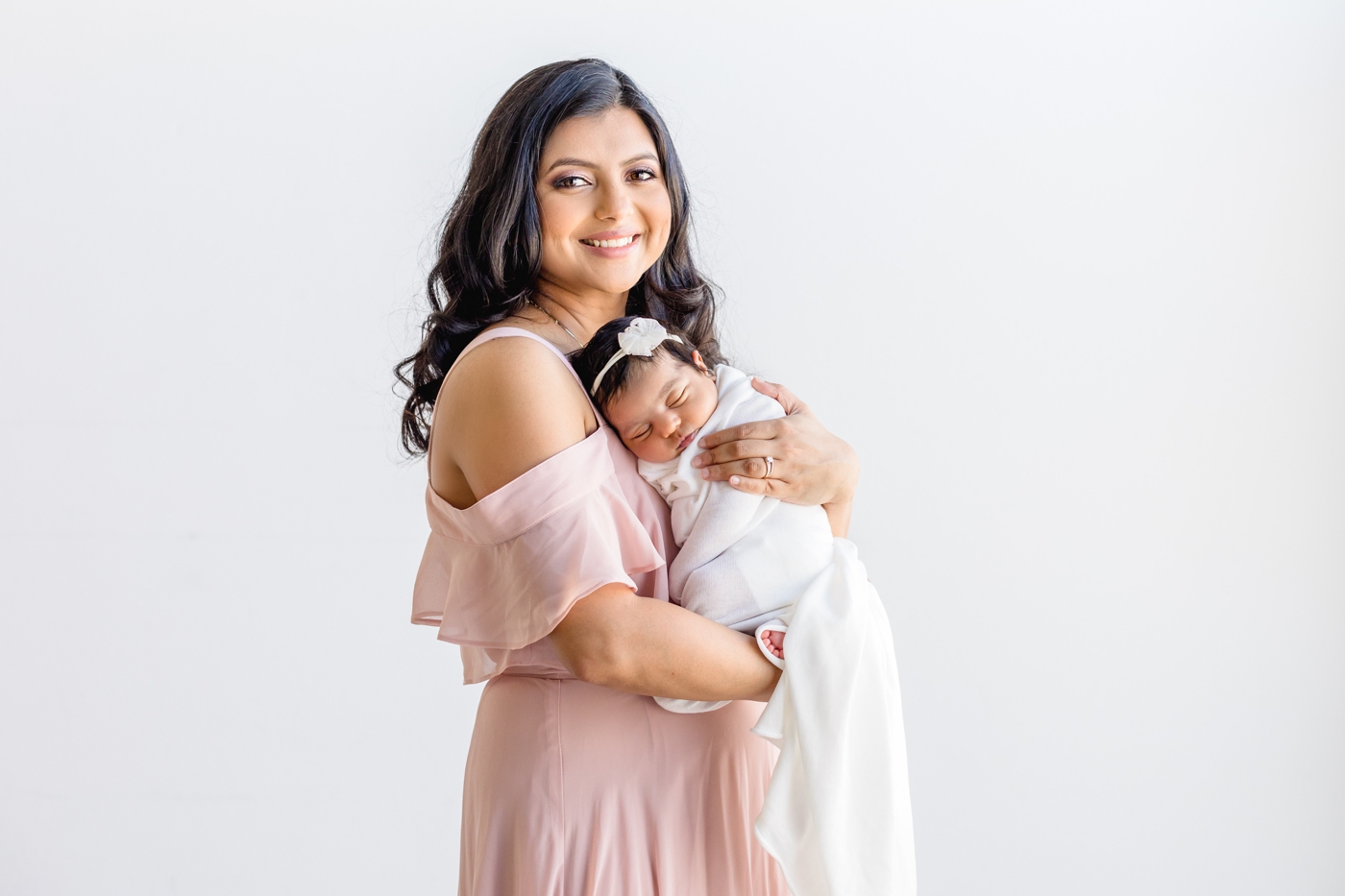 Baby curled up on Mom's chest during newborn session with Sana Ahmed Photography.