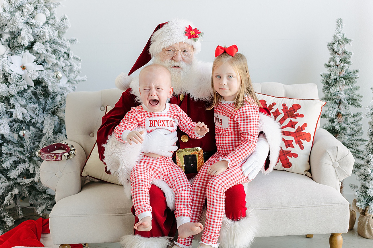 Siblings sitting with Santa during luxury pictures with Santa event in Austin, TX studio.