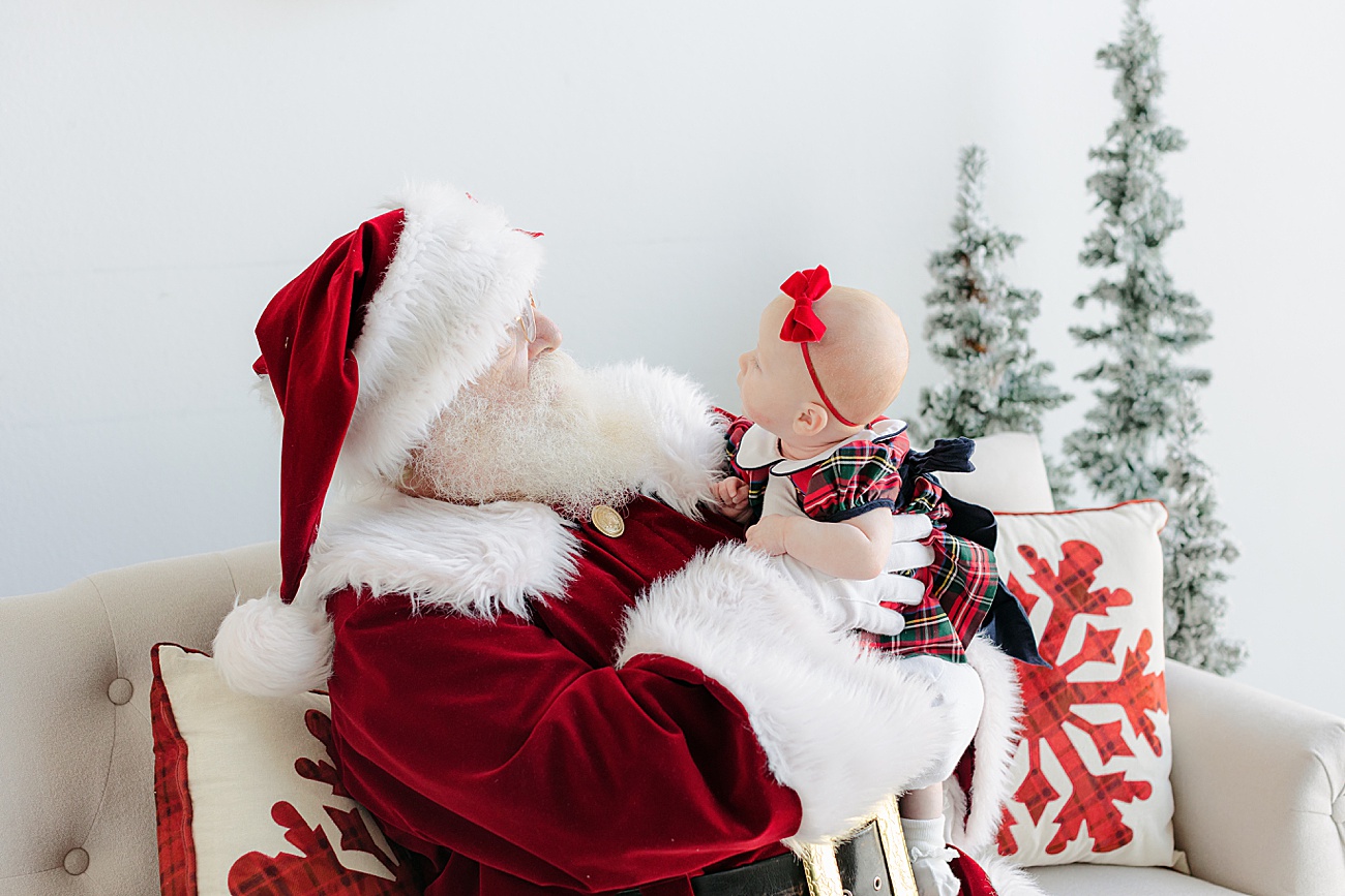 Baby girl looking at Santa during mini session event with Sana Ahmed Photography.