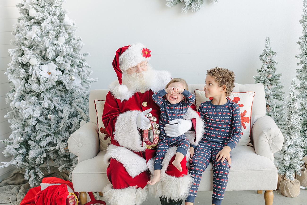 Little boys on Santa's lap during luxury pictures with Santa event in Austin, TX with Sana Ahmed Photography.