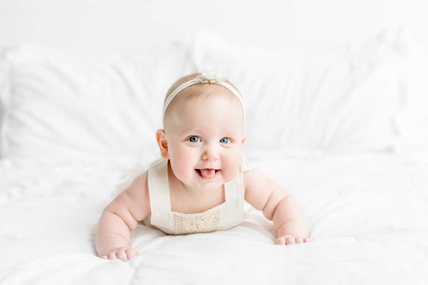 Smiling baby girl with her tongue out during 6 month milestone photos with Sana Ahmed Photography.