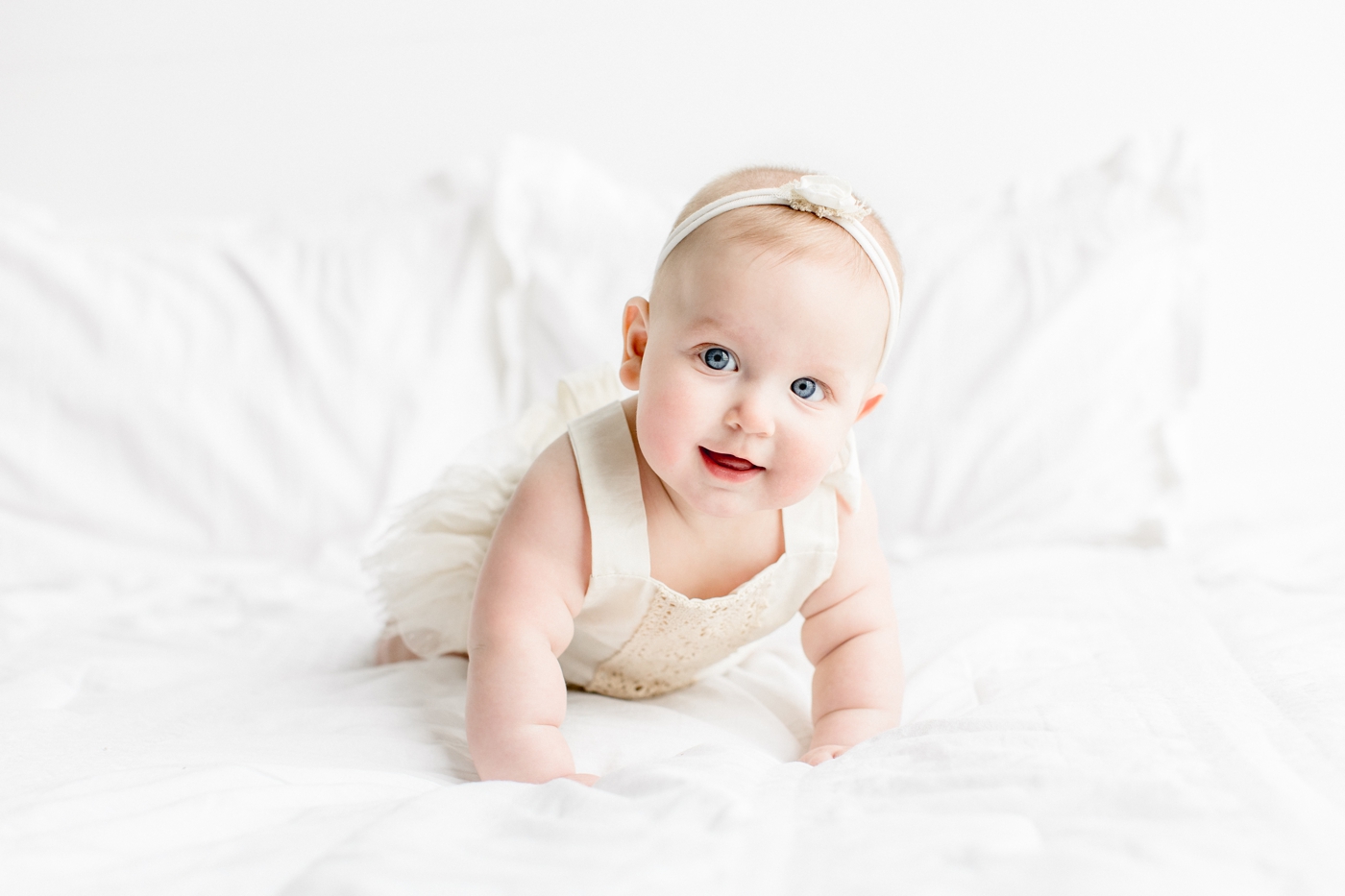 Baby girl pushing up on her arms during tummy time. Photo by Sana Ahmed Photography.
