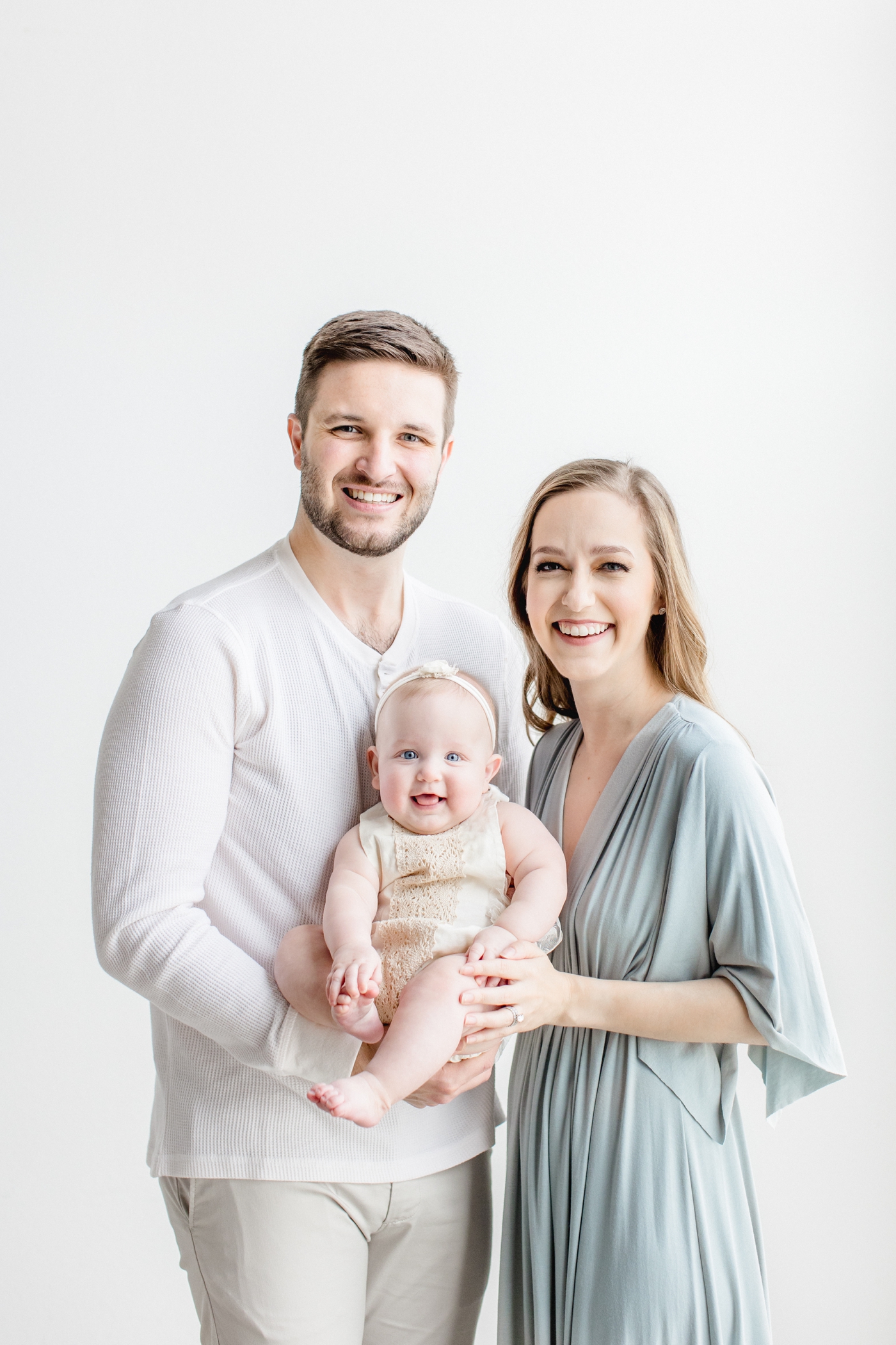 Family photo with baby girl smiling at camera. Photo by Austin photogrpaher, Sana Ahmed Photography.