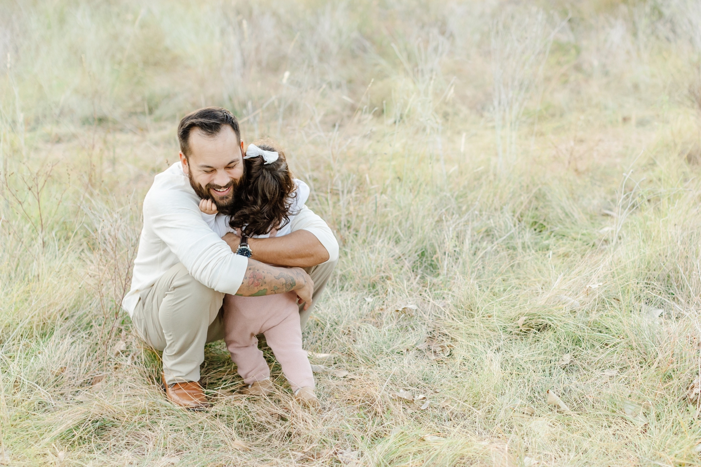 Dad and daughter hug during park family session in Austin. Photo by Sana Ahmed Photography.