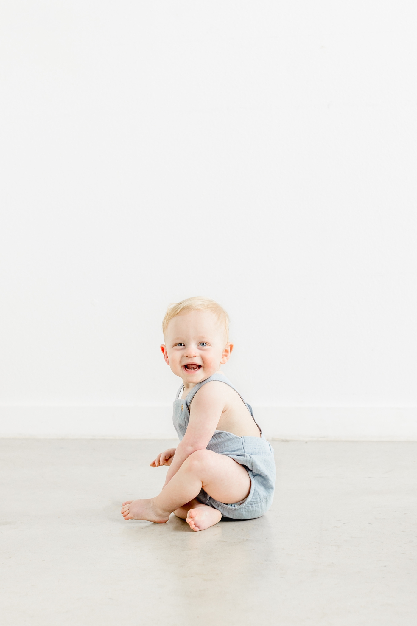 First birthday milestone session with baby crawling on studio floor. Photo by Sana Ahmed Photography.