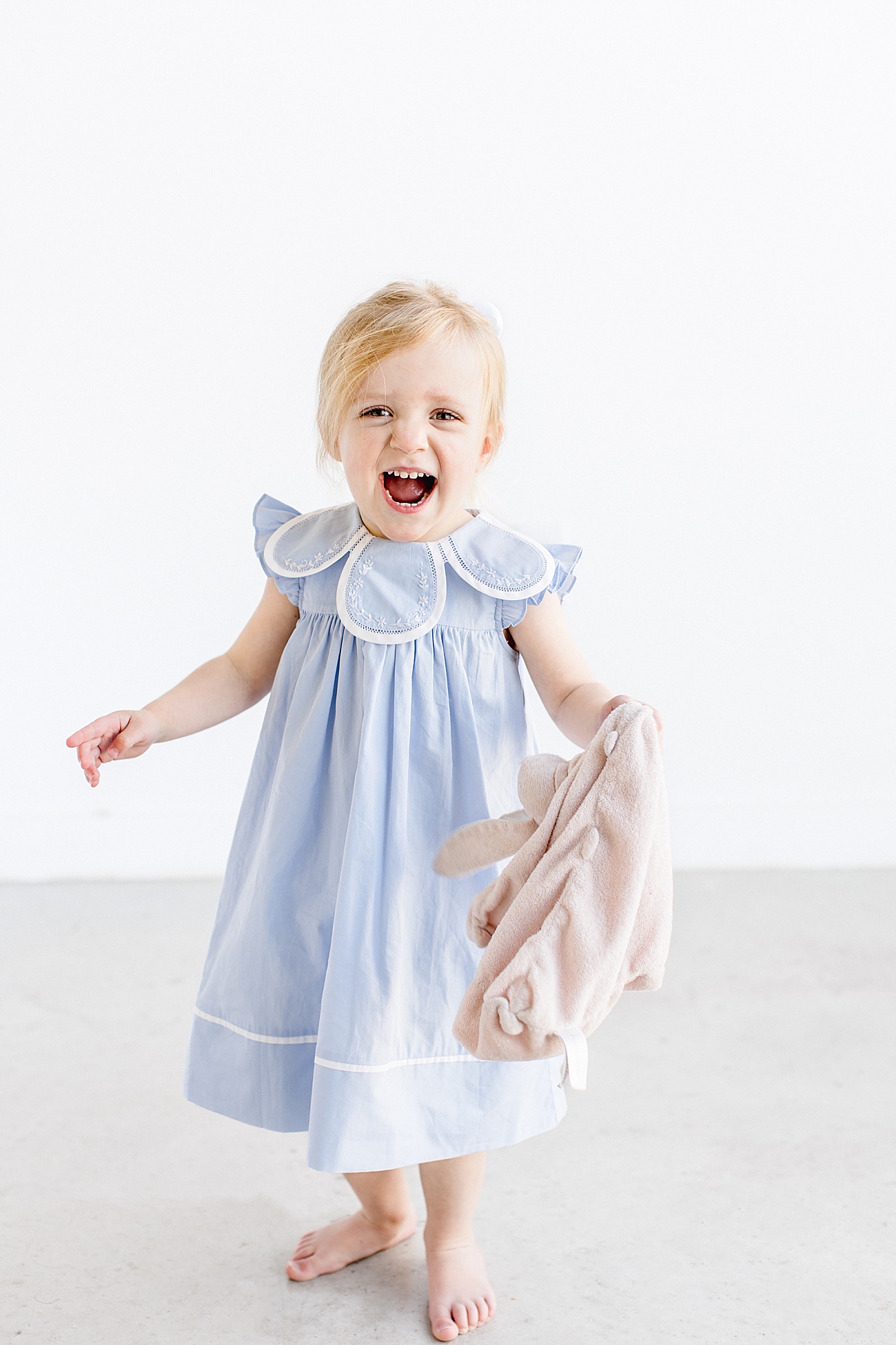 Happy big sister in blue petal collar dress. Photo by Sana Ahmed Photography.
