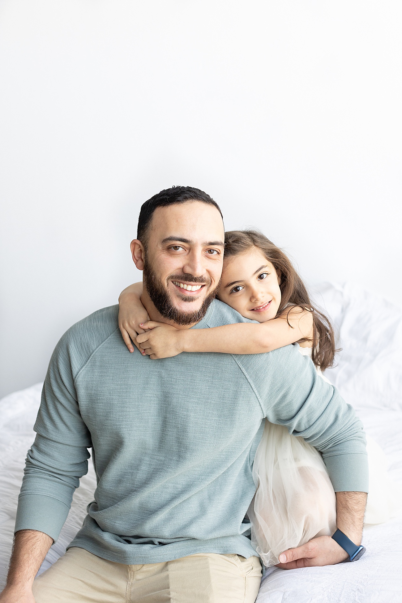 Dad and daughter smiling at the camera during photoshoot in Austin, TX. Photo by Sana Ahmed Photography.
