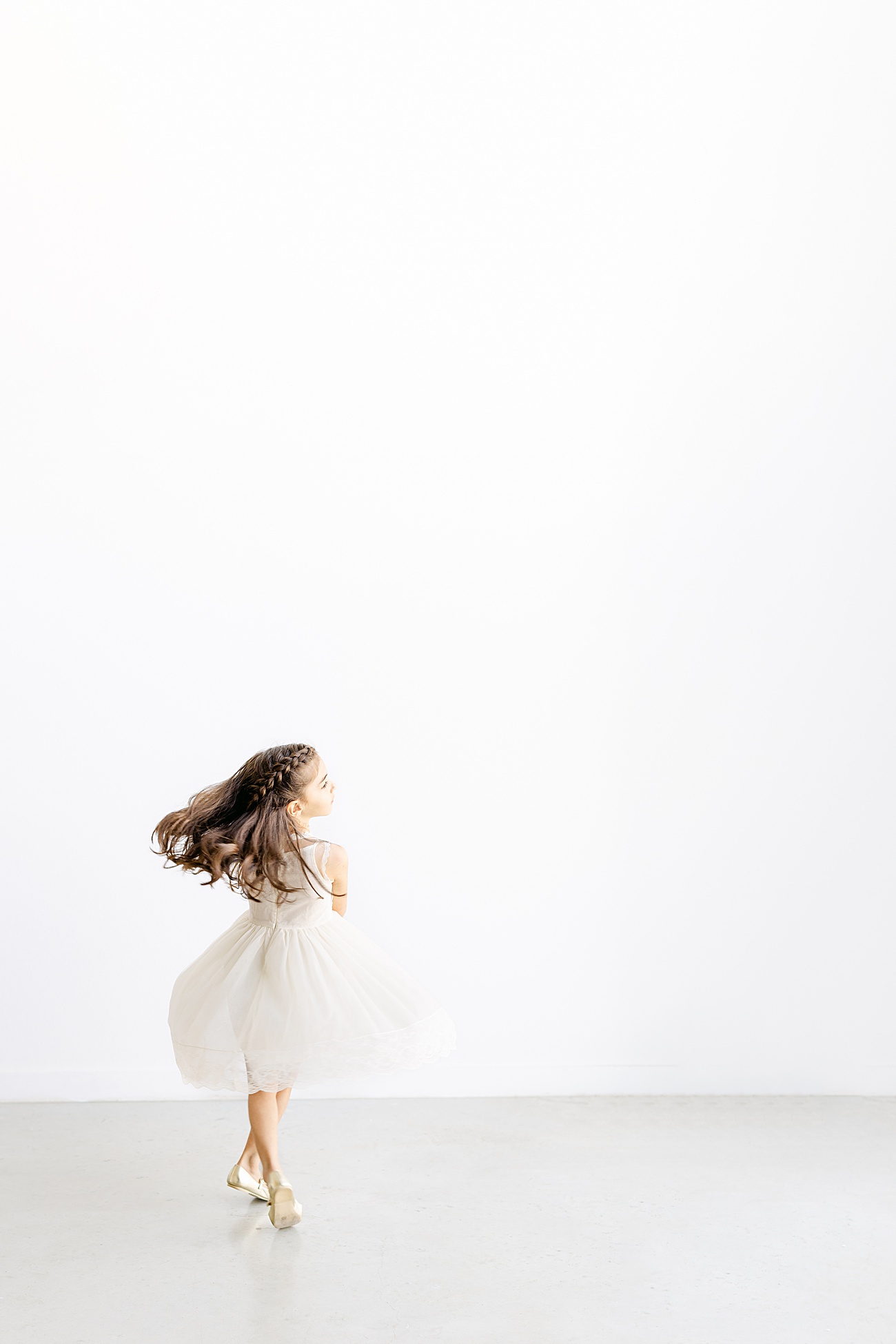 Little girl twirling during portrait session. Photo by Sana Ahmed Photography.